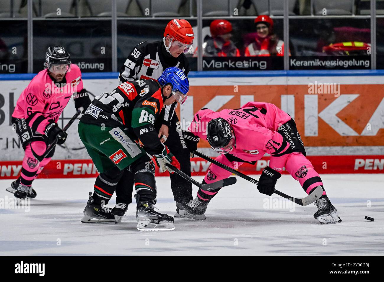 Augsburg, Deutschland. Oktober 2024. Linesperson Jonas Reinold fuehrt ein Bully aus zwischen Mark Zengerle (Augsburger Panther, #89) und Justin Feser (Grizzlys Wolfsburg, #71). Deutschland, Augsburger Panther gegen Grizzlys Wolfsburg, Eishockey, DEL, 7. Spieltag, Saison 2024/2025, 06.10.2024. Foto: Eibner-Pressefoto/Heike feiner Credit: dpa/Alamy Live News Stockfoto