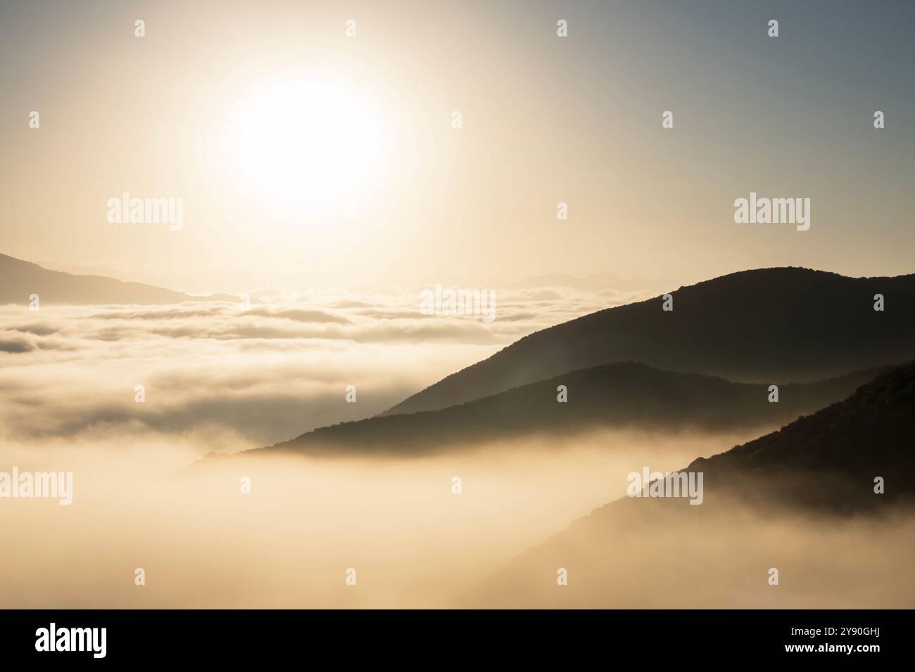 Bernsteinfarbener Sonnenaufgang über niedrigen Wolken und Bergrücken in Los Angeles, Kalifornien. Stockfoto