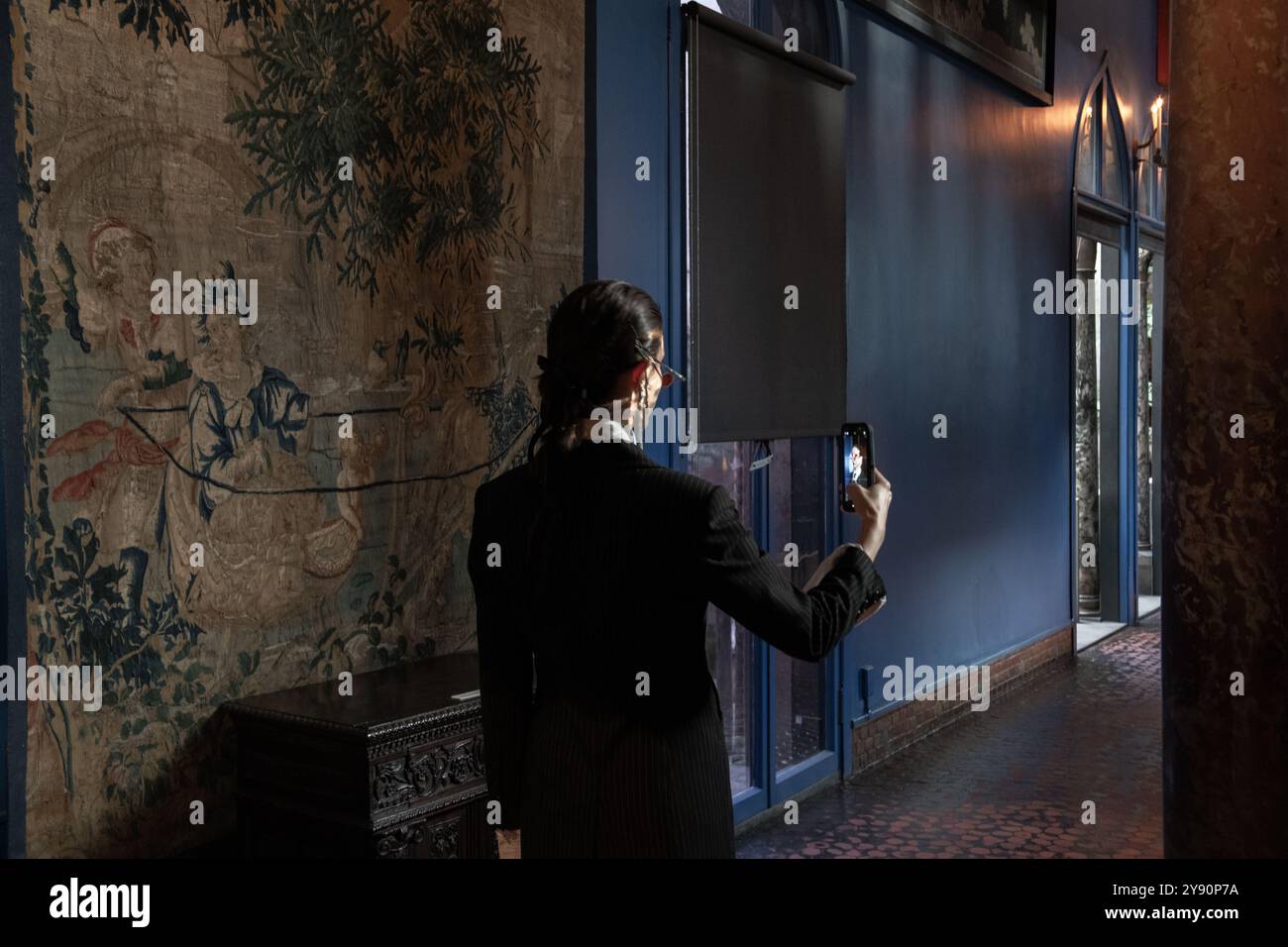 Dunkle Materie. Mädchen in Schwarz in einem Maul und wird im Smartphone gespiegelt Stockfoto