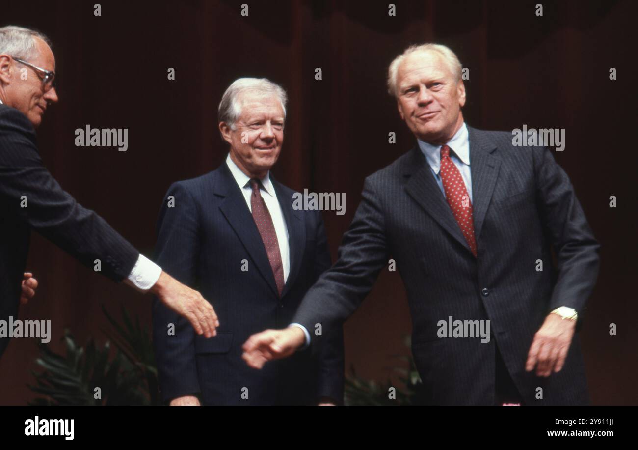 Der Historiker Stephen Ambrose (links) greift, um dem ehemaligen US-Präsidenten Gerald Ford (rechts) die Hand zu schütteln, während der ehemalige Präsident Jimmy Carter (Mitte) vor einer Debatte an der MSC Wiley Lecture Series an der Texas A&M University im November 1986 die Hand gibt. ©Bob Daemmrich Stockfoto