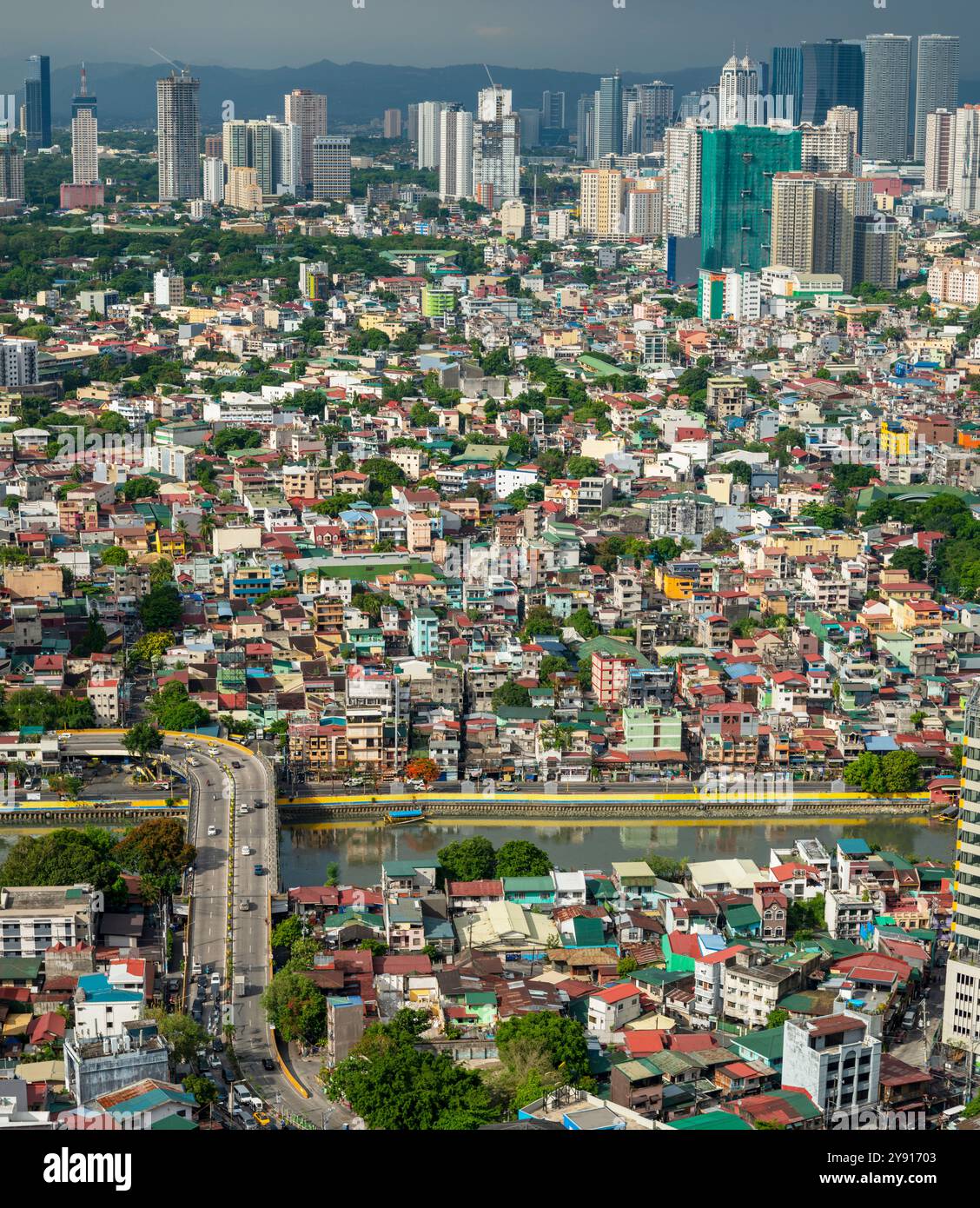 Die Hauptstadt ist hell beleuchtet, von der niedrigen Sonneneinstrahlung Pasig River fließt durch das Stadtzentrum, zwischen eng abgeteilten städtischen Gebäuden. Stockfoto