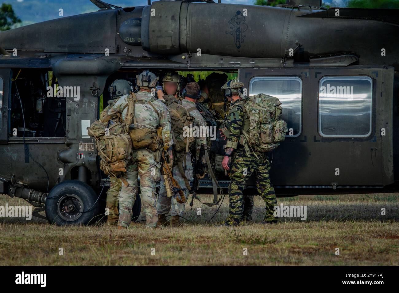 Green Berets, die der 10. Special Forces Group (Airborne) zugewiesen wurden, besteigen am 7. August 2024 einen UH-60 Black Hawk Hubschrauber in den Schofield Barracks, Oahu, Hawaii. Dies war der Beginn der letzten Übung für die gemeinsame Trainingsübung NAKOA FLEEK, bei der diese Operatoren Soldaten der 25. Infanteriedivision für kriegerische Aufgaben und Kampfübungen ausbildeten und evaluierten. Stockfoto