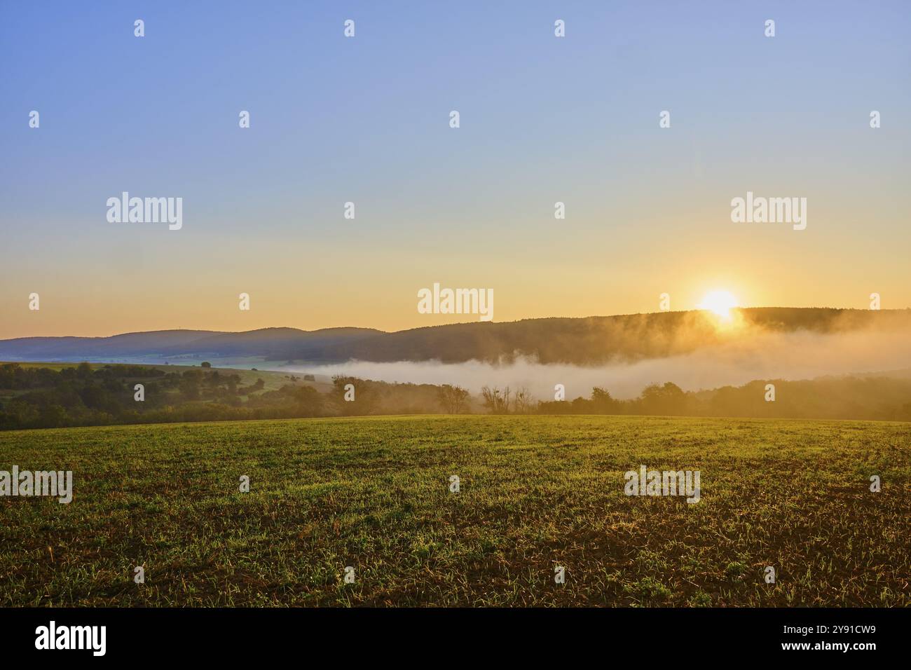 Ruhige Morgenszene mit Sonnenaufgang über nebelbedeckten Hügeln und Getreidefeldern, Grossheubach, Miltenberg, Spessart, Bayern, Deutschland, Europa Stockfoto