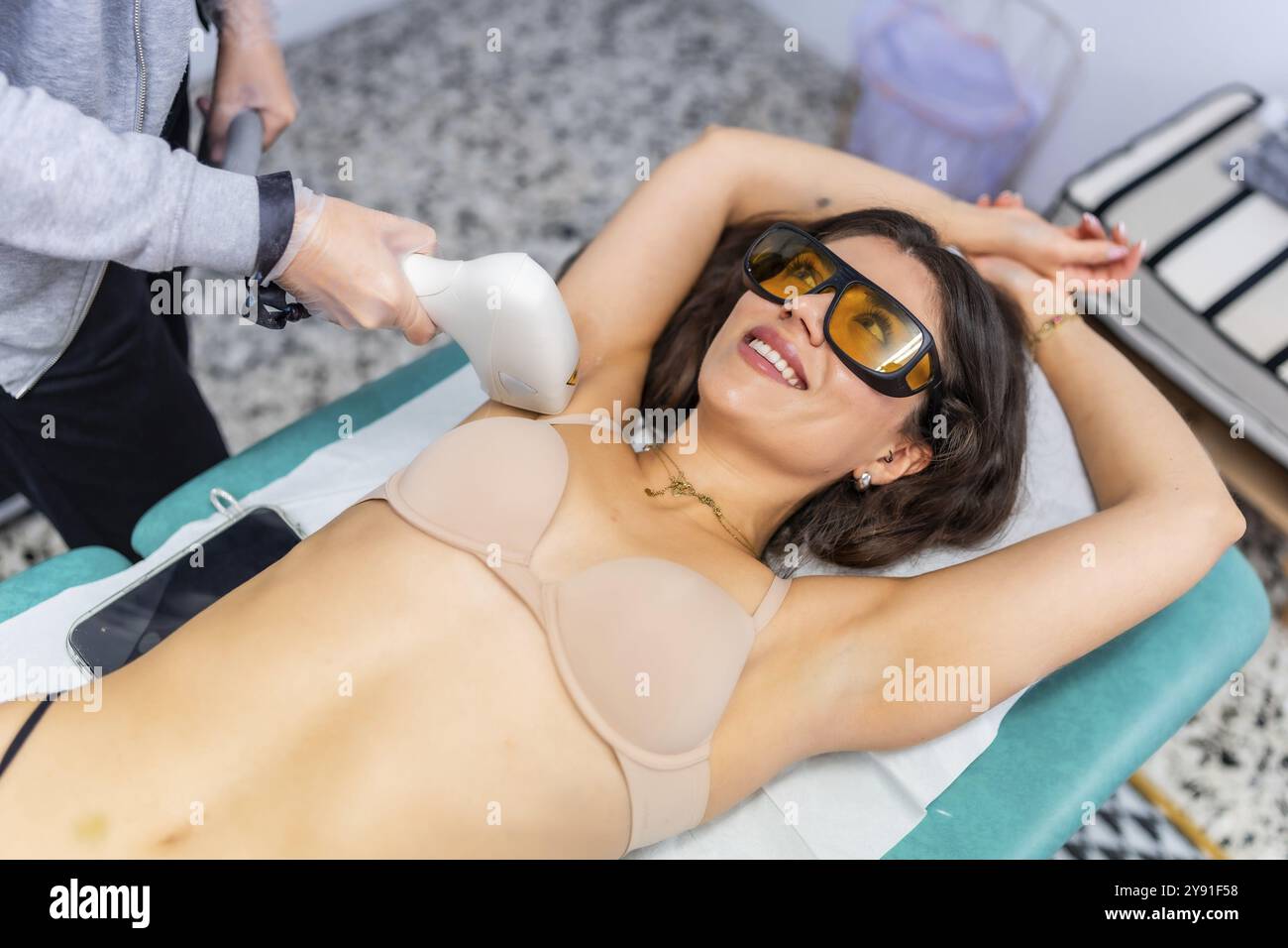 Frau im Spa, die sich Laserhaare in den Achseln entfernen lässt Stockfoto