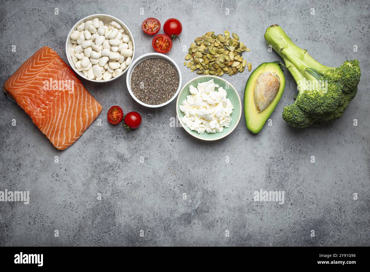 Auswahl gesunder Nahrungsmittel, wenn eine Person Diabetes hat: Lachsfisch, Brokkoli, Avocado, Bohnen, Gemüse, Seeds auf grauem Hintergrund von oben. Stockfoto