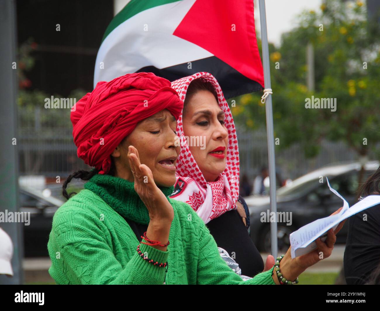 Lima, Peru. Oktober 2024. Frauen in Hidschab mit palästinensischen Fahnen, als Dutzende Demonstranten in Solidarität mit Palästina und dem Libanon auf die Straße gingen, um den ersten Jahrestag des Krieges zwischen Israel und der Hamas zu feiern, der am 7. Oktober 2023 begann, als die Hamas Israelis beim Nova-Musikfestival tötete und entführte. Quelle: Fotoholica Presseagentur/Alamy Live News Stockfoto