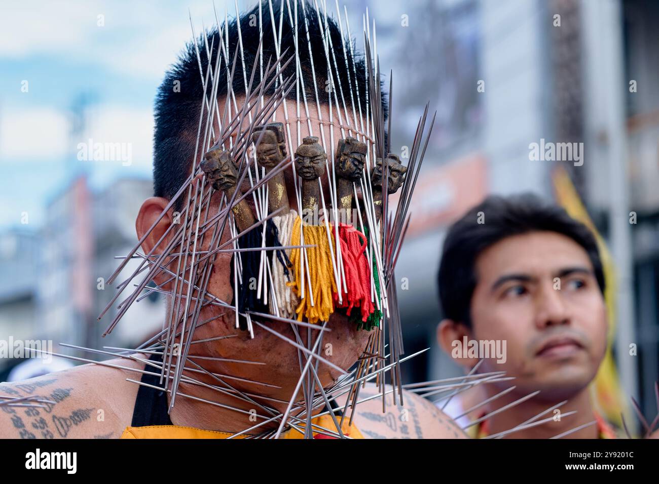 Während des vegetarischen Festivals in Phuket Town, Thailand, zeigt ein mAh Song oder ein spirituelles Medium eine Vielzahl von Spitzen, die durch seine Gesichtshaut durchbohrt werden Stockfoto