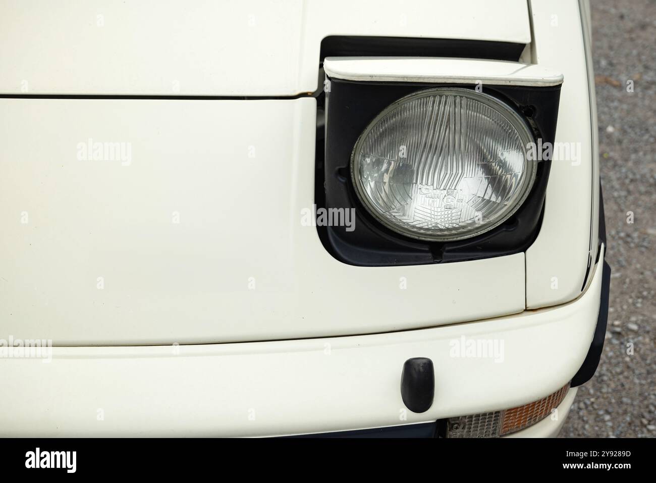 Junge Zeitschaltuhr oder Oldtimer, offene ausklappbare Scheinwerfer oder Scheinwerfereinheit. Nahaufnahme, von oben nach unten, keine Personen. Stockfoto