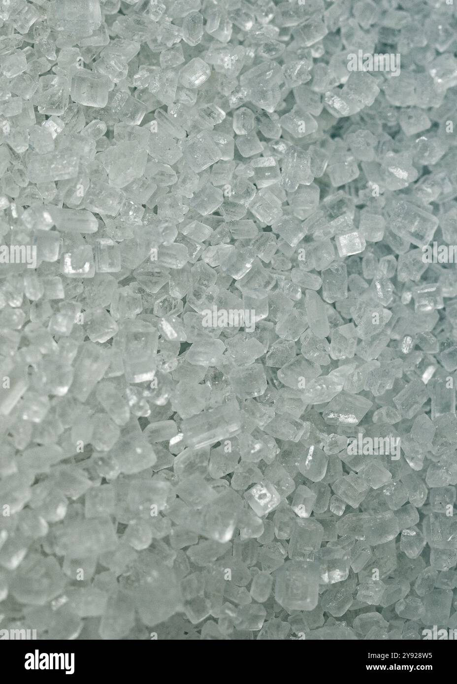 Weiße Zuckerkristalle aus nächster Nähe. Vertikales Makrofoto. Stockfoto