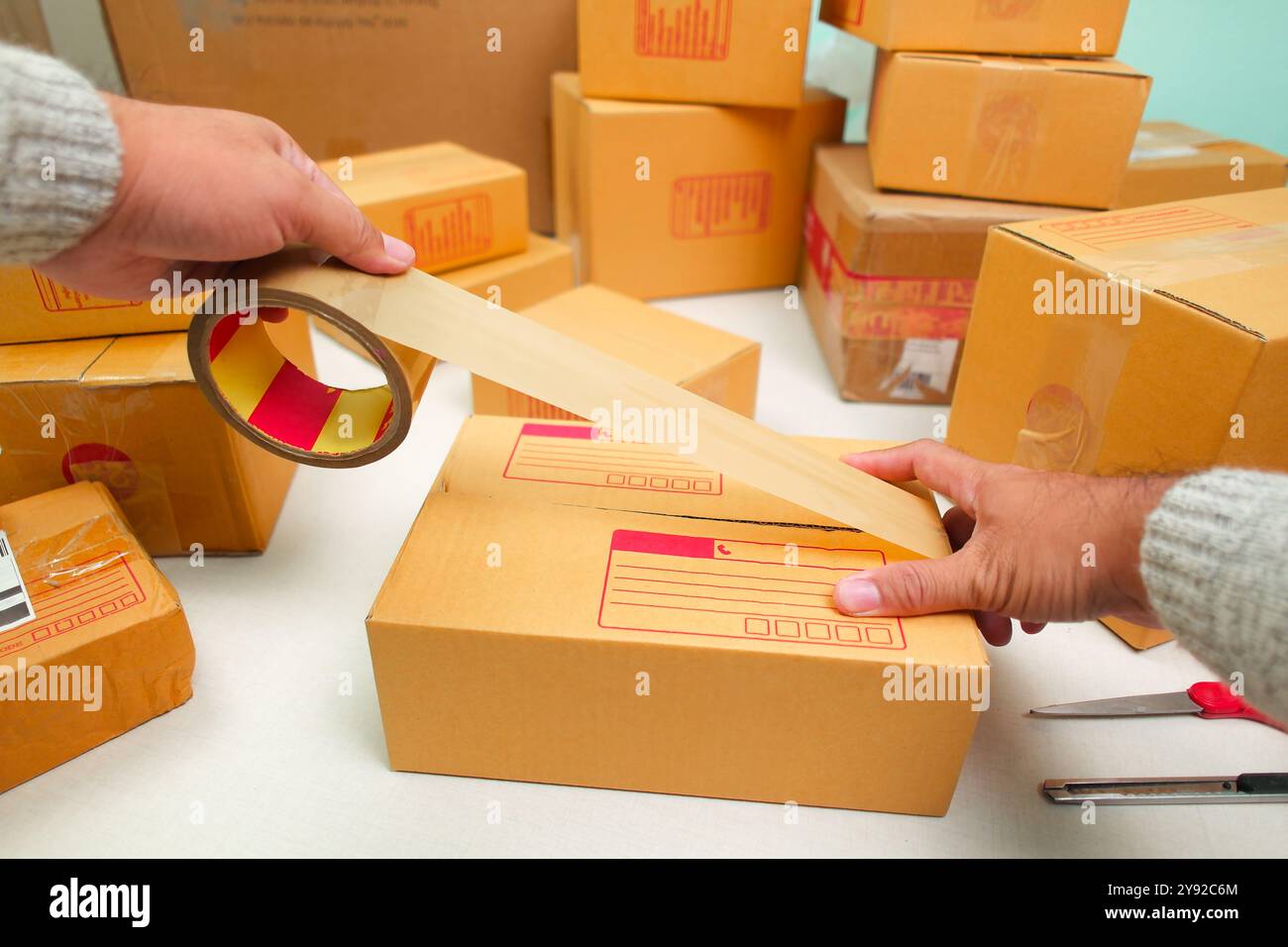 Versiegelte eine Warenkarton mit Kartonversiegelungsband für Lieferung auf Bestellung, Online-Verkäufer und Warenlieferkonzept Stockfoto