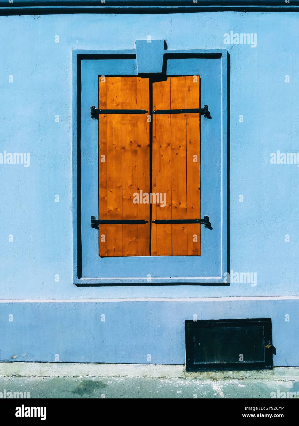 Alte Fensterläden aus Holz am Haus mit blauer Fassadenwand, vertikales Bild - Smartphone-aufgenommenes Stockfoto
