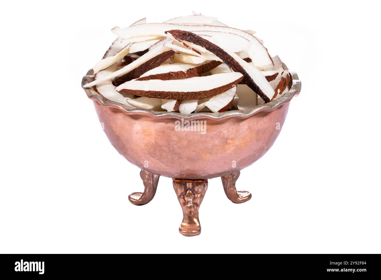 Frisch geschnittene Kokosnussstücke in einer traditionellen Kupferschale, perfekt für tropische Lebensmittelkonzepte. Stockfoto