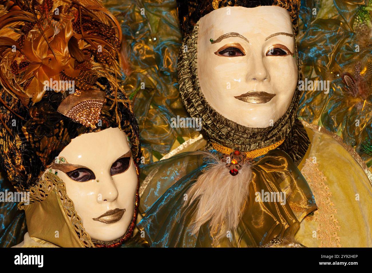 Auffällige, lebendige Farben der Masken und exotischen Kostüme, die von zwei Teilnehmern des jährlichen venezianischen Karnevals in Annecy, Frankreich, öffentlich präsentiert werden Stockfoto