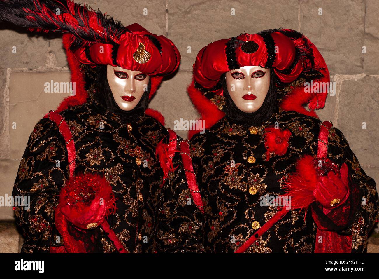 Auffällige, lebendige Farben der Masken und exotischen Kostüme, die von zwei Teilnehmern des jährlichen venezianischen Karnevals in Annecy, Frankreich, öffentlich präsentiert werden Stockfoto