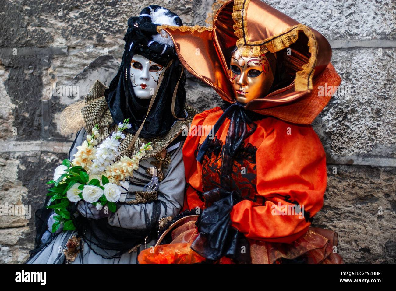 Auffällige, lebendige Farben der Masken und exotischen Kostüme, die von zwei Teilnehmern des jährlichen venezianischen Karnevals in Annecy, Frankreich, öffentlich präsentiert werden Stockfoto