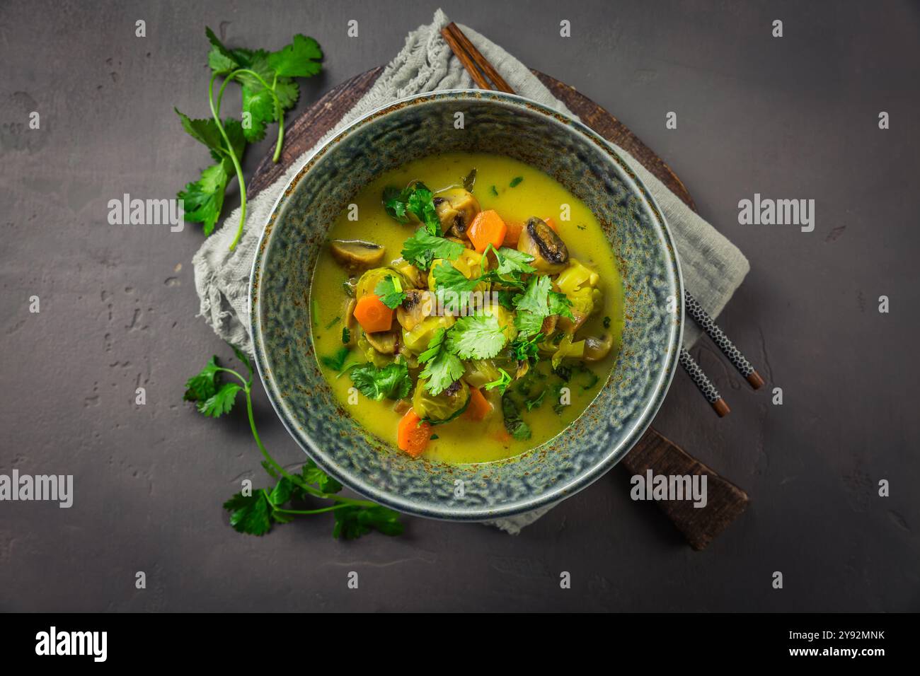 Grüne Currysuppe mit Rosenkohl, Pilzen und Koriander Stockfoto