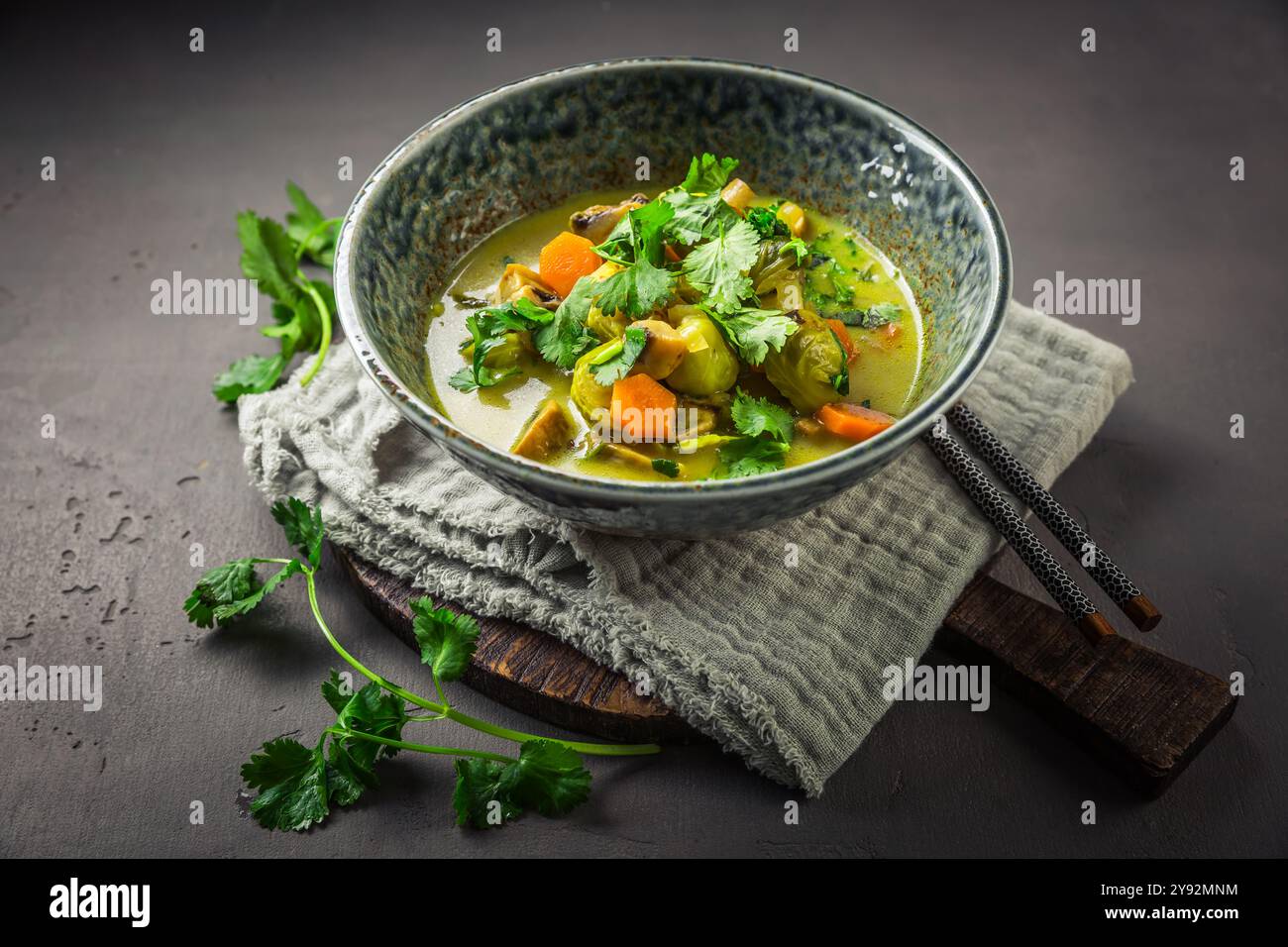 Grüne Currysuppe mit Rosenkohl, Pilzen und Koriander Stockfoto