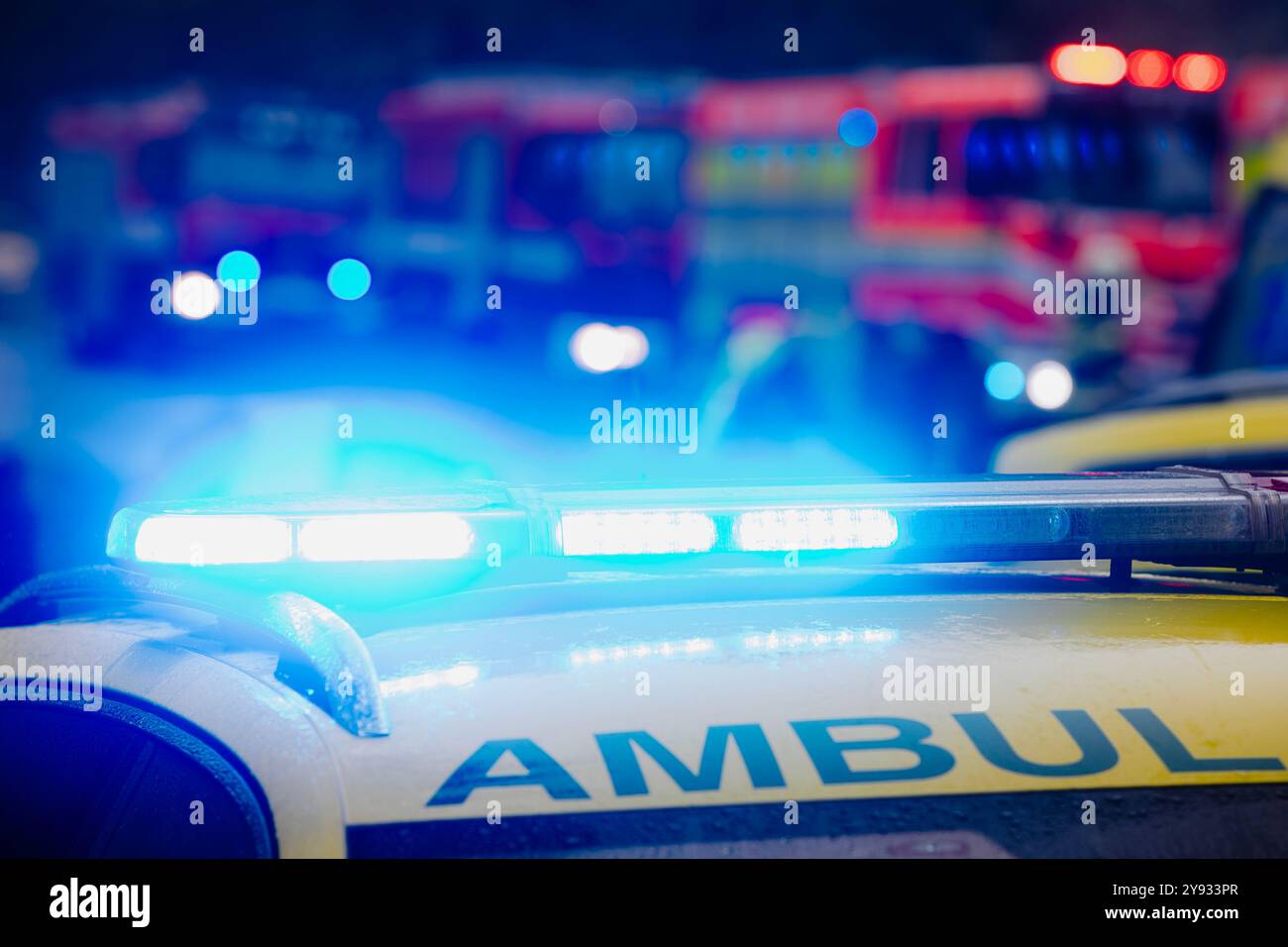 Nahaufnahme des Blinkers auf dem Dach des Ambulanzwagens des Rettungsdienstes auf der Straße gegen Feuerwehrfahrzeuge. Themen Rettung, Unfälle und Katastrophen. Stockfoto