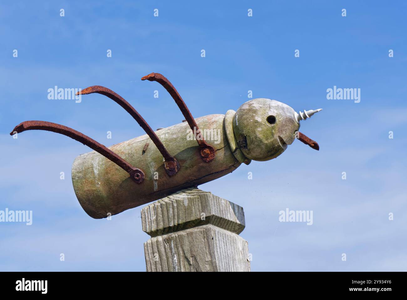 Skurrile Skulptur einer Biene mit geformtem Holz und Schrott an einem Straßenposten, The Lizard, Cornwall, Großbritannien, Juni. Stockfoto