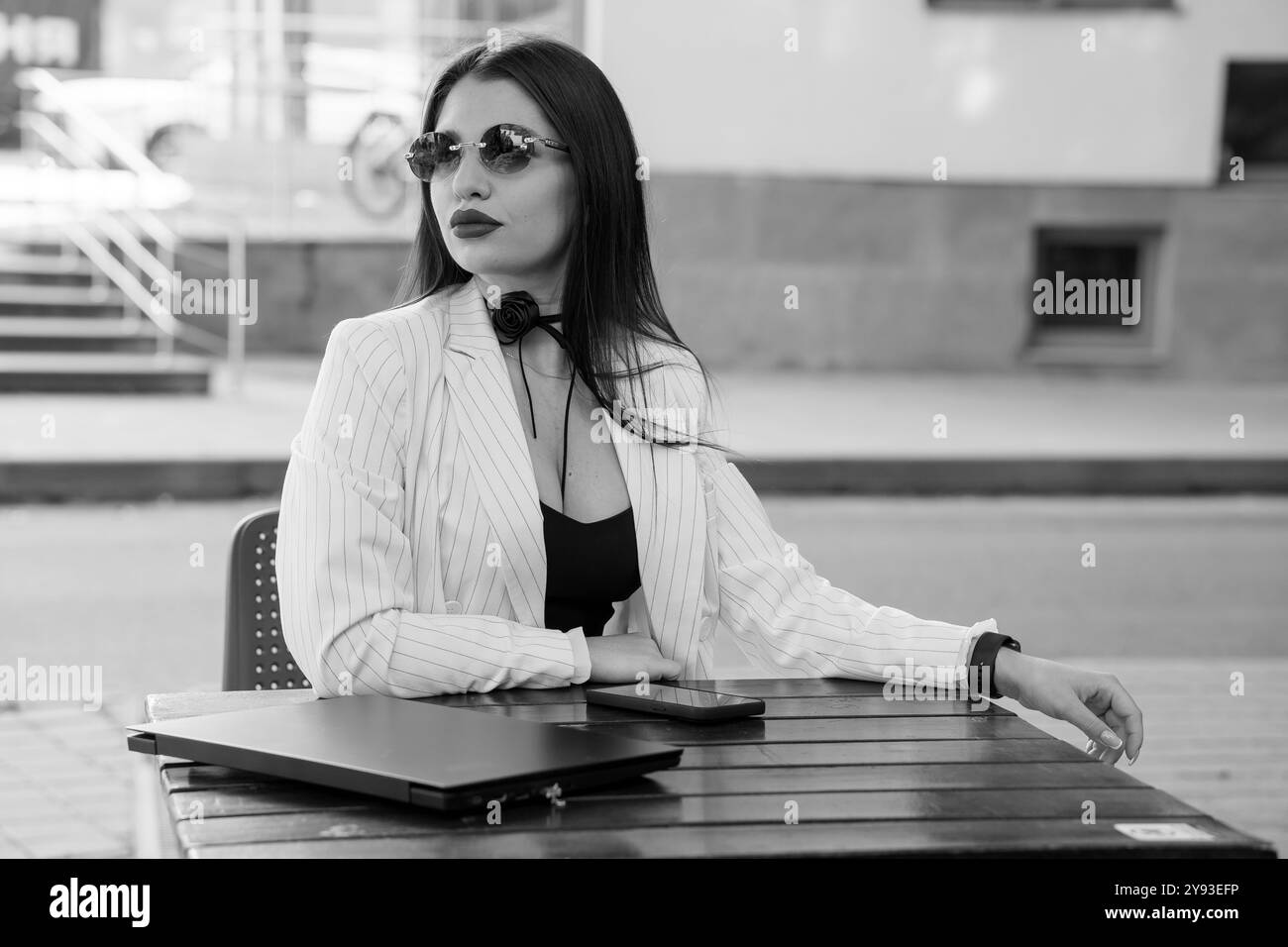 Eine modische Geschäftsfrau, die sich in einem modernen Café in schicker Kleidung entspannt. Stockfoto