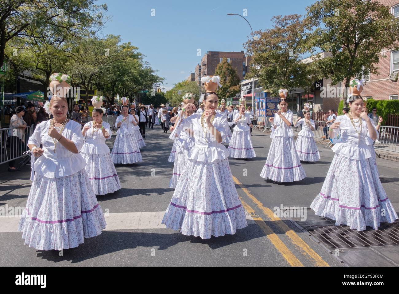 Eine Gruppe paraguayischer Frauen tanzen und marschieren in weißen Kostümen. Bei der Queens Hispanic Day Parade 2024 in Jackson Heights. Stockfoto