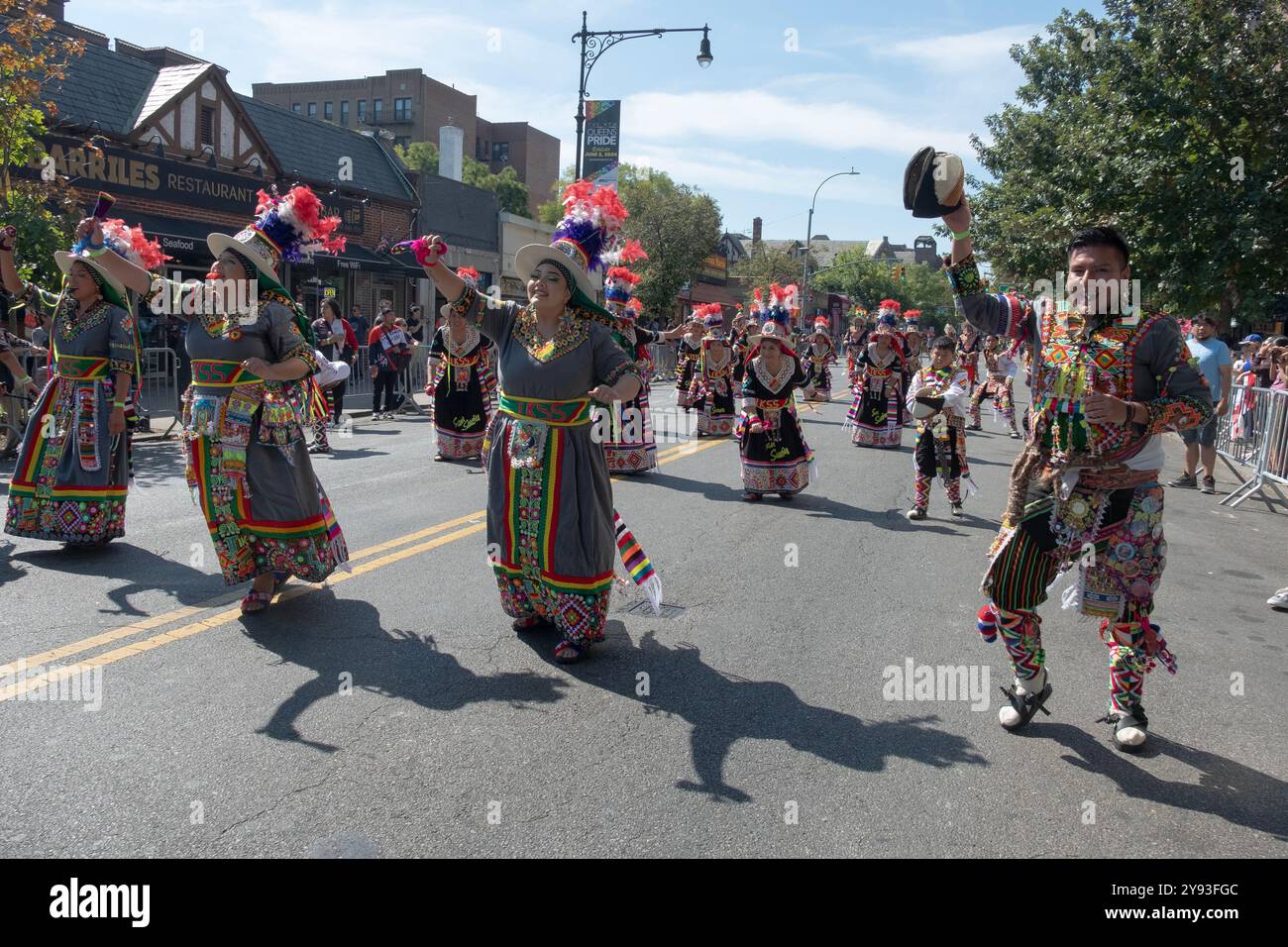 TKSS-Tänzer in fantastischen bunten Kostümen marschieren an der 37th Ave. In Jackson Heights bei der Hispanic Heritage Day Parade. Stockfoto