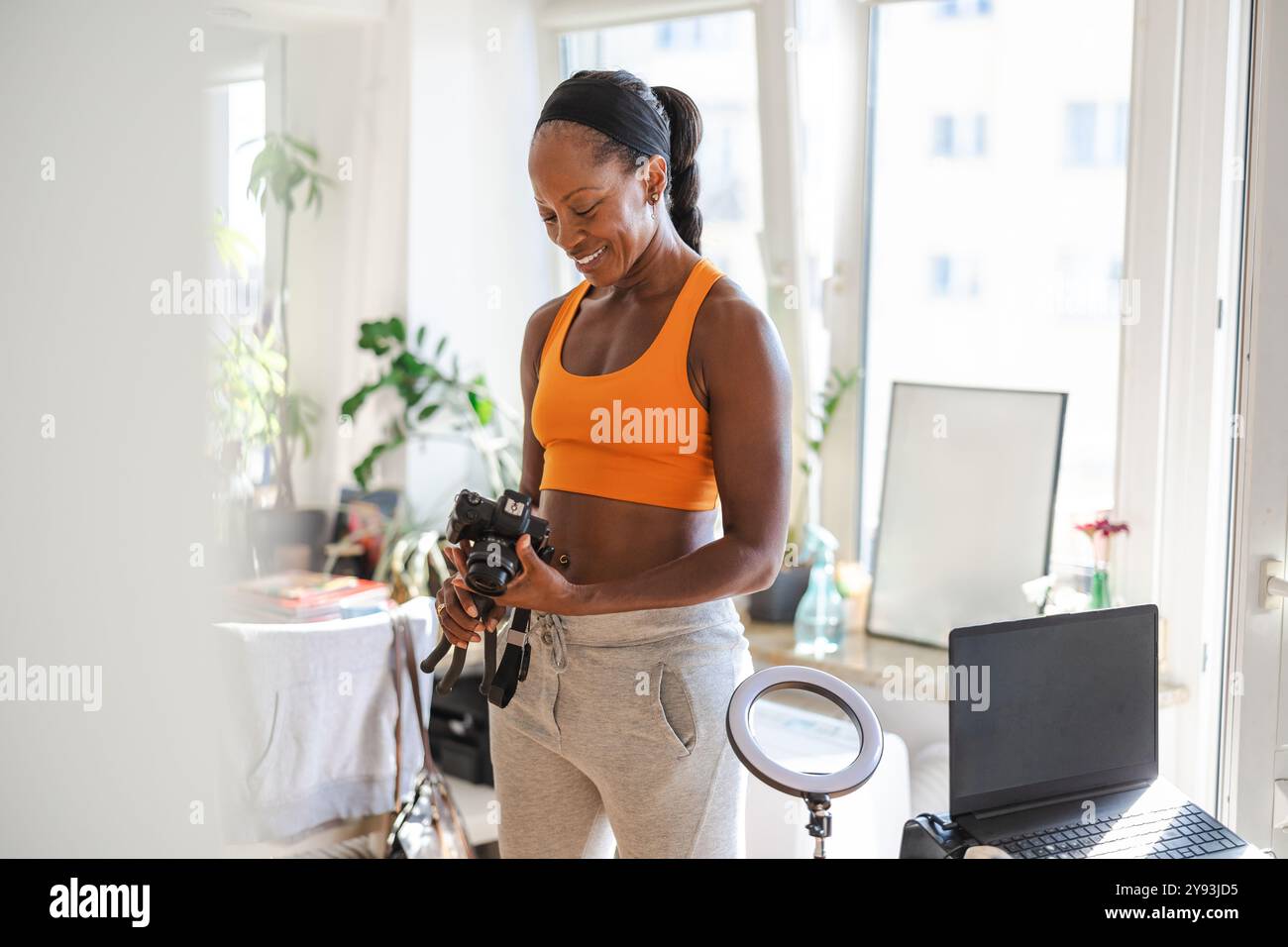 Lächelnde Frau in Sportkleidung zu Hause Stockfoto