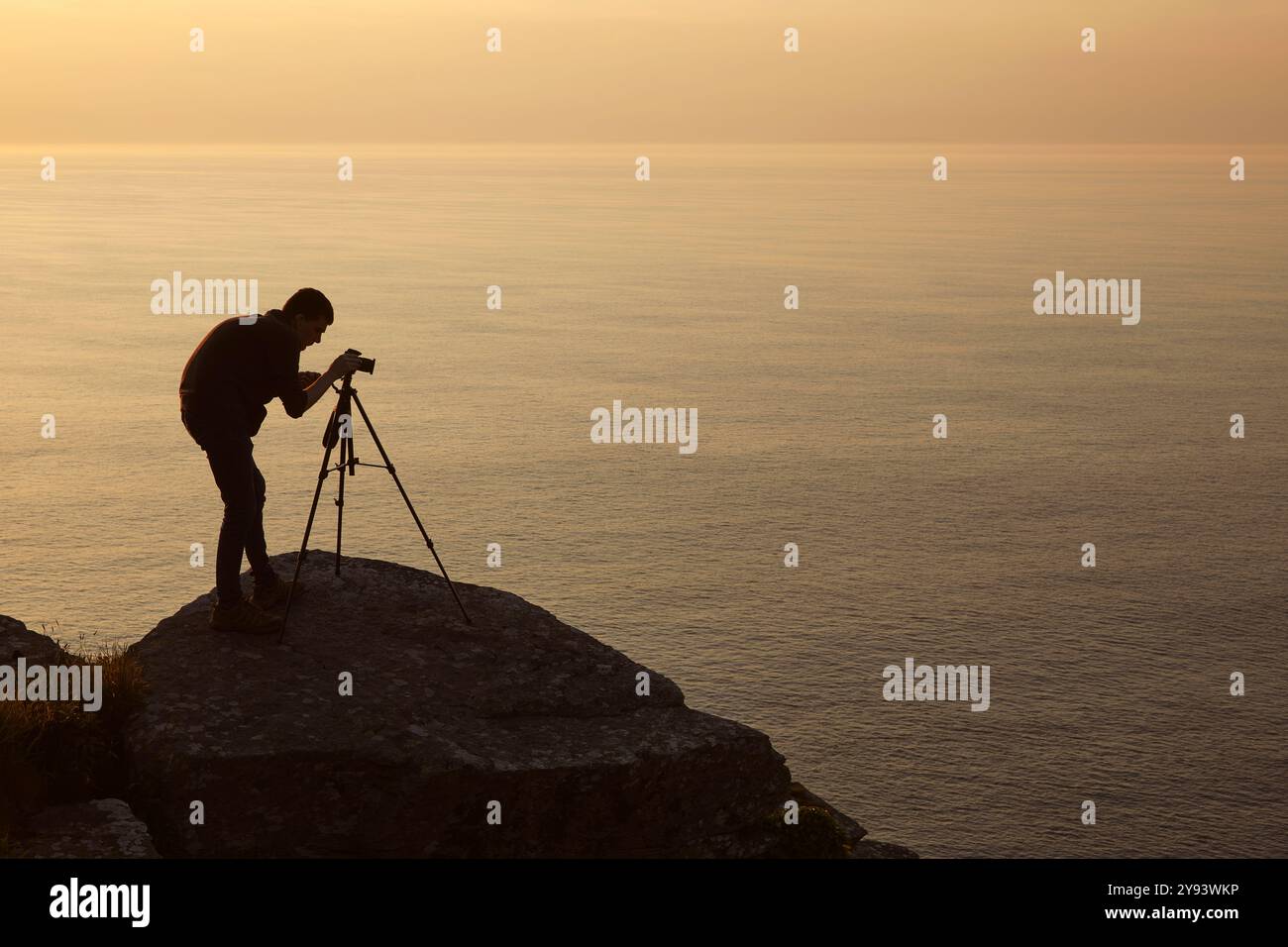 Ein Landschaftsfotograf bei der Arbeit, an der Bristol Channel Küste im Valley of Rocks, nahe Lynton, Exmoor National Park, Devon, England Stockfoto