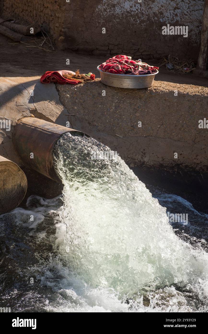 Waschen neben dem Abfluss, der Wasser aus dem Nil pumpt, um einen Bewässerungskanal rund um das Dorf Ramadi in Ägypten zu versorgen Stockfoto