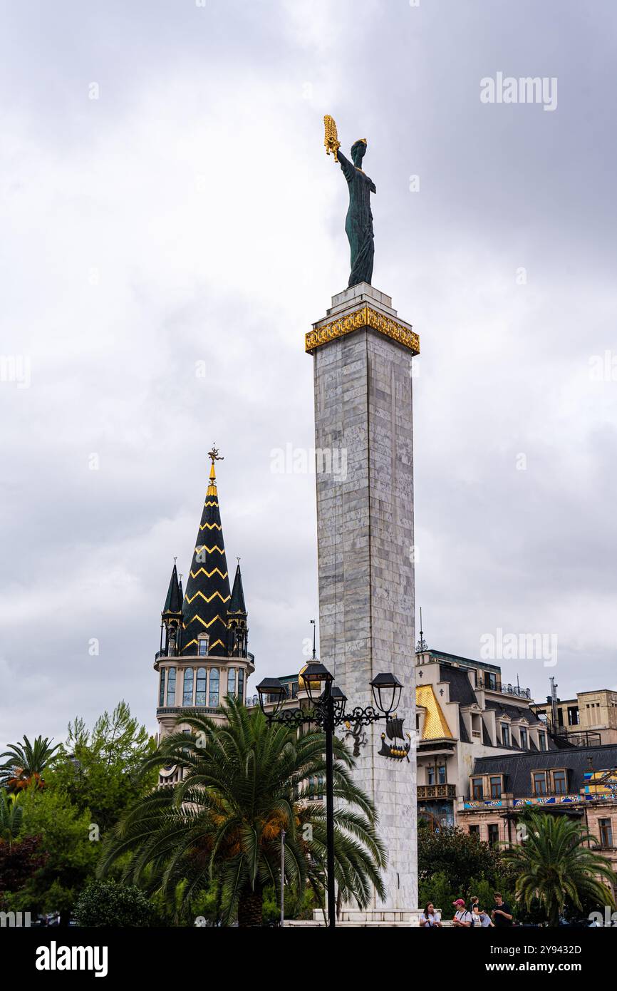 Eine majestätische Darstellung der Statue von Medea, die das goldene Vlies in Batumi hält, vor dem Hintergrund eklektischer Architekturstile Stockfoto