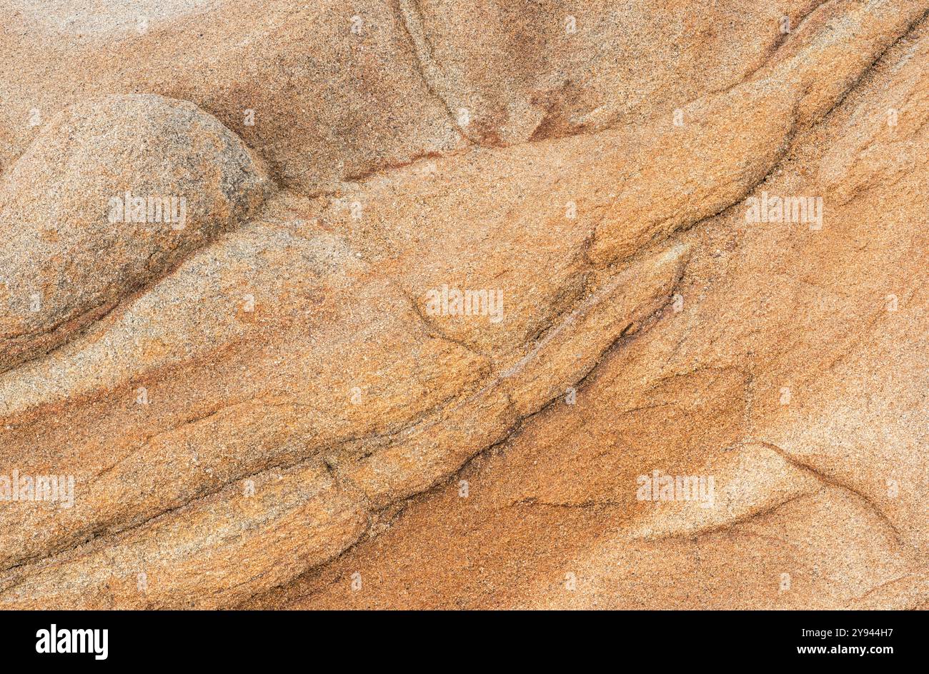 Ein detailliertes Nahbild, das die natürlichen Strukturen und Muster einer Sandsteinoberfläche mit verschiedenen Orange- und Brauntönen zeigt Stockfoto