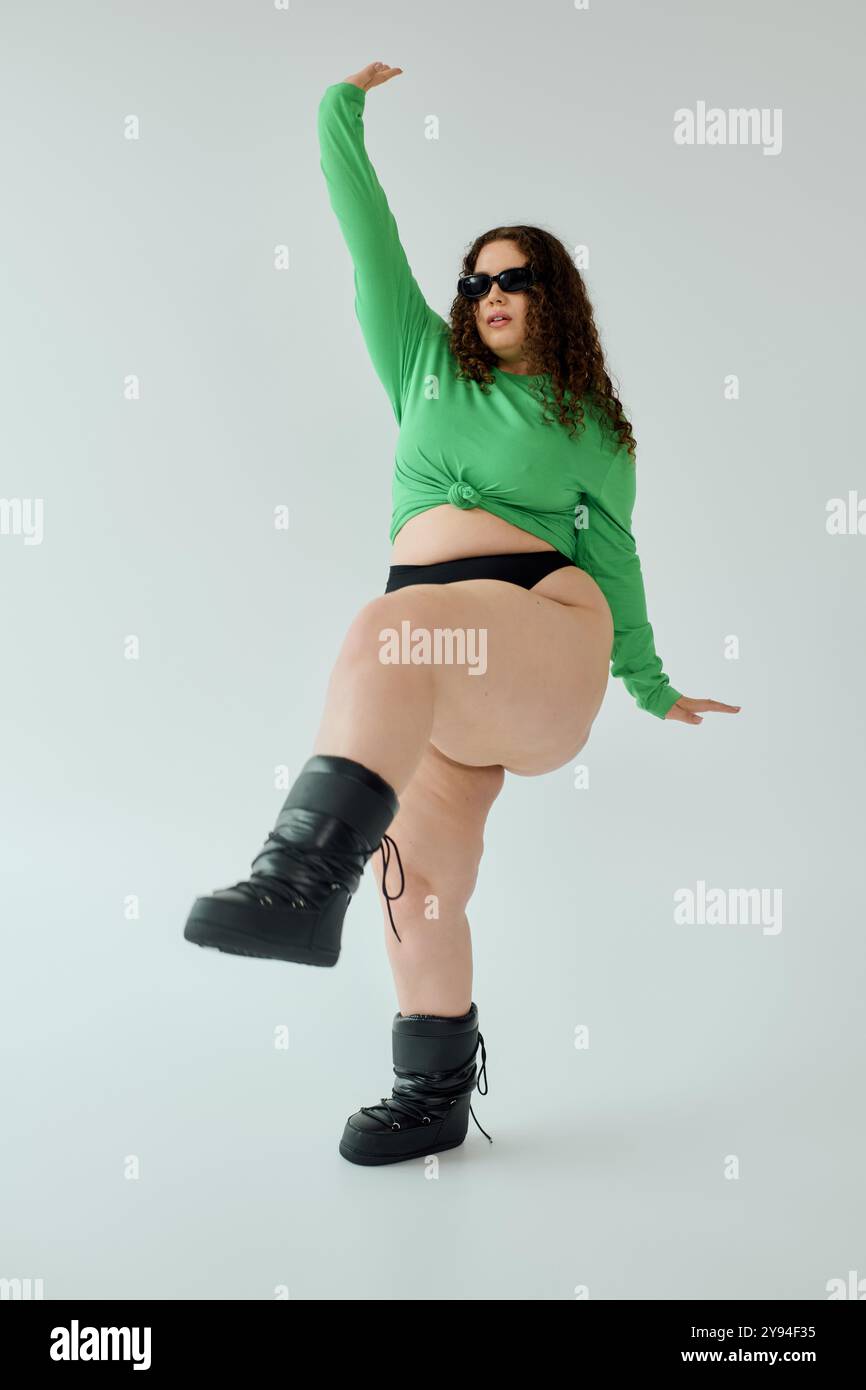 Die Frau in Übergröße zeigt ihr Selbstvertrauen in einer auffälligen Pose und trägt auffällige Styles. Stockfoto