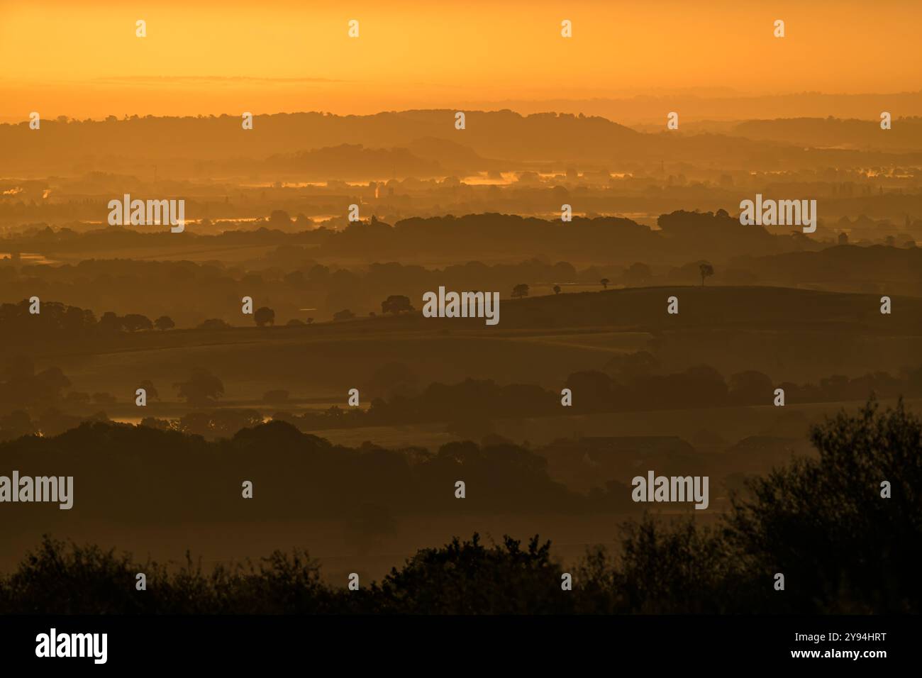 Atemberaubende Aussicht von den Quantock Hügeln kurz vor Sonnenaufgang mit Blick ins Landesinnere in Richtung Südosten mit Schichten von sanften Hügeln, Bäumen und niedrig liegenden Nebel Stockfoto