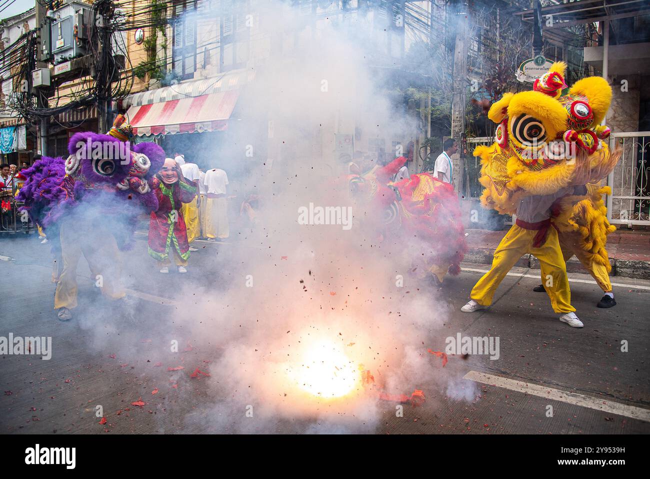 Bangkok, Thailand. Oktober 2024. Tänzer führen einen Löwentanz neben Feuerwerkskörpern während des vegetarischen Festivals im Yaowarat in Chinatown in Bangkok auf. Das annaul vegetarische Festival in Thailand findet vom 3. Bis 12. Oktober 2024 statt und die Anbeter verzichten auf tierische Produkte während der neun Tage, und dies fällt mit der Feier der neun chinesischen Kaiser-Götter zusammen. Quelle: SOPA Images Limited/Alamy Live News Stockfoto