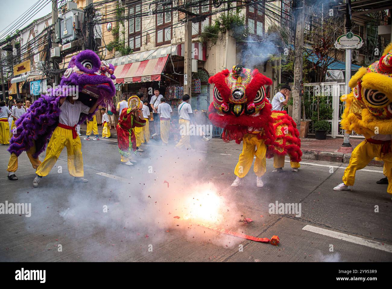 Bangkok, Thailand. Oktober 2024. Tänzer führen einen Löwentanz neben Feuerwerkskörpern während des vegetarischen Festivals im Yaowarat in Chinatown in Bangkok auf. Das annaul vegetarische Festival in Thailand findet vom 3. Bis 12. Oktober 2024 statt und die Anbeter verzichten auf tierische Produkte während der neun Tage, und dies fällt mit der Feier der neun chinesischen Kaiser-Götter zusammen. (Foto: Peerapon Boonyakiat/SOPA Images/SIPA USA) Credit: SIPA USA/Alamy Live News Stockfoto