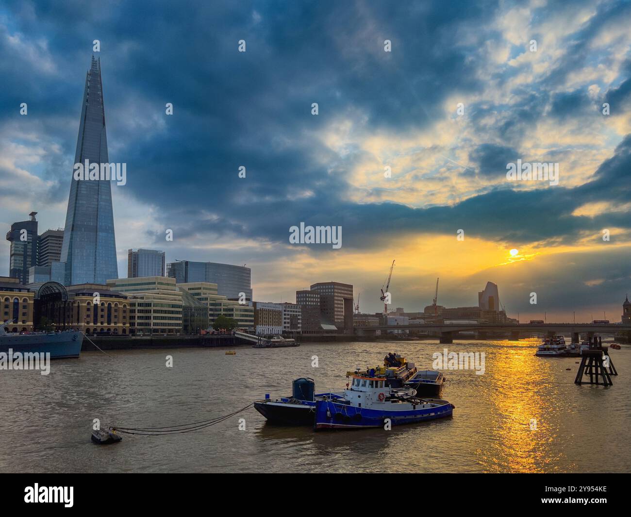 Stimmungsvolles Abendlicht auf der Themse, das einen festgefahrenen Schlepper mit dem Scherben im Hintergrund zeigt. London, Großbritannien Stockfoto