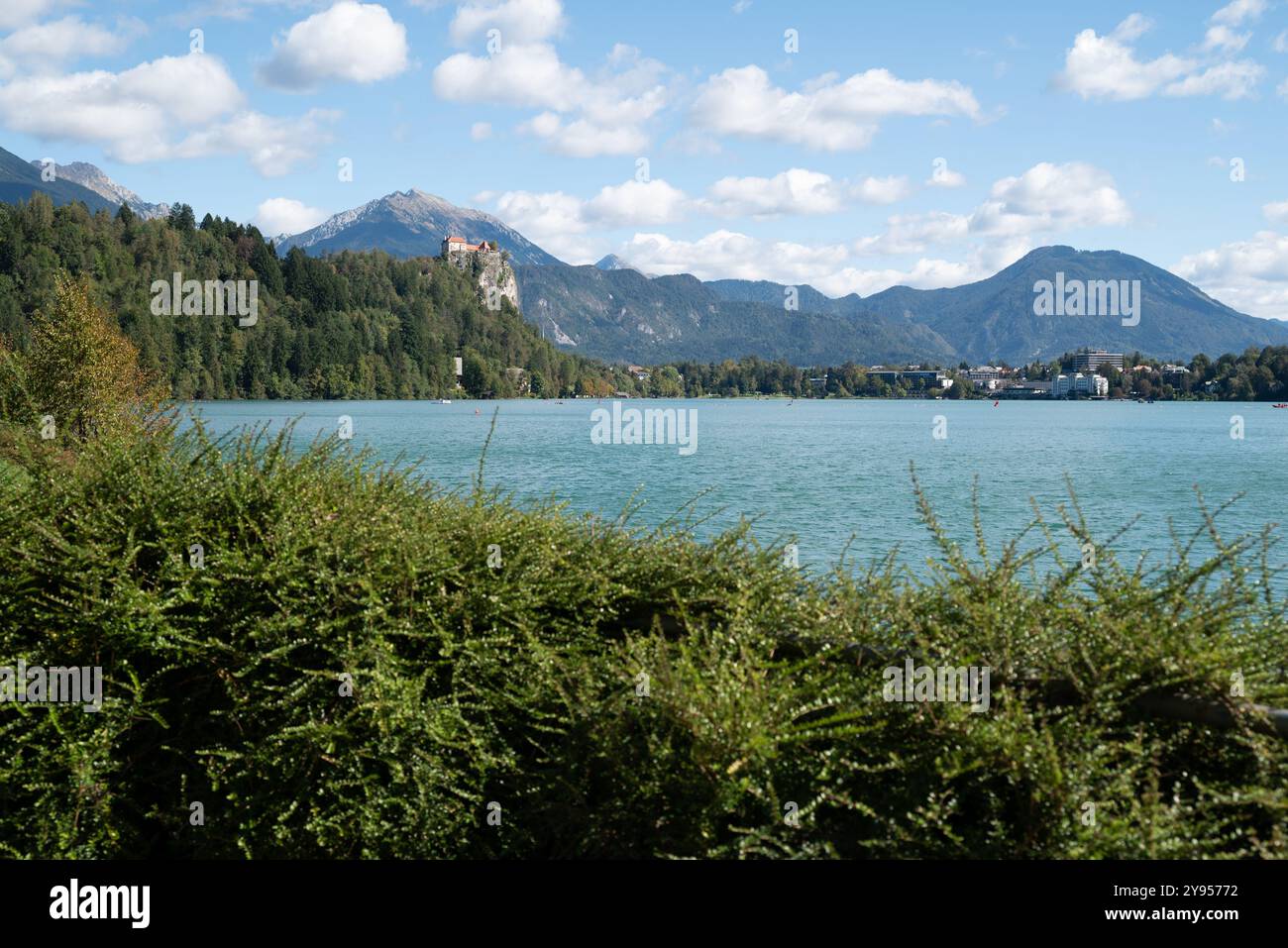 Blick auf die Stadt Bled in den Julischen Alpen (Slowenien). Wir sehen das Schloss und das blaue reine Wasser, die grünen Hügel, die herrlichen Berge an einem sonnigen Tag Stockfoto