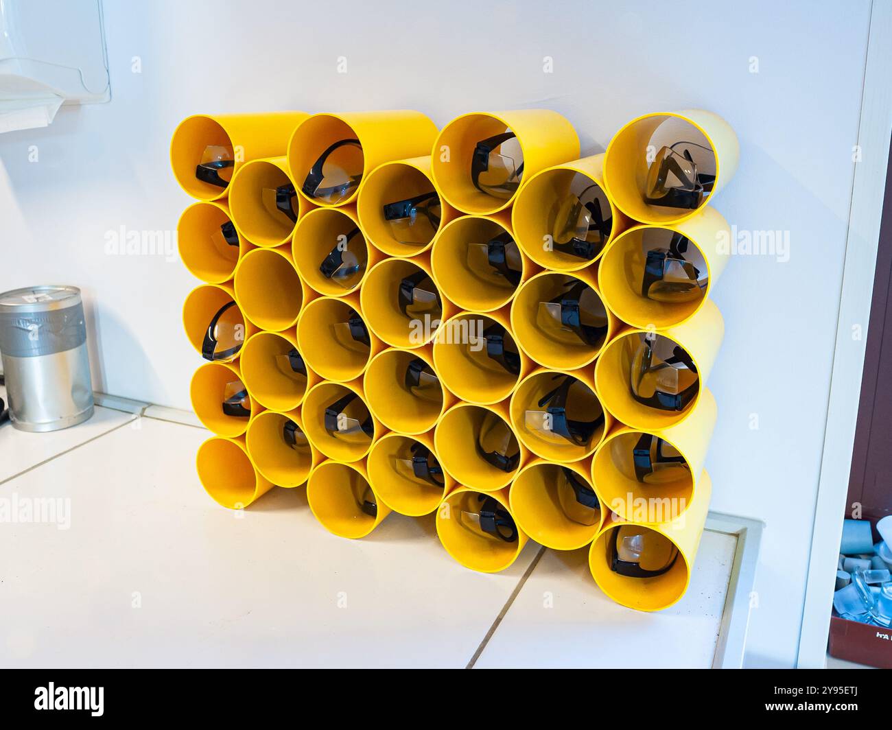 Gelbe Röhrchen mit Schutzbrille für die Chemie, die an einer High School praktiziert wird Stockfoto