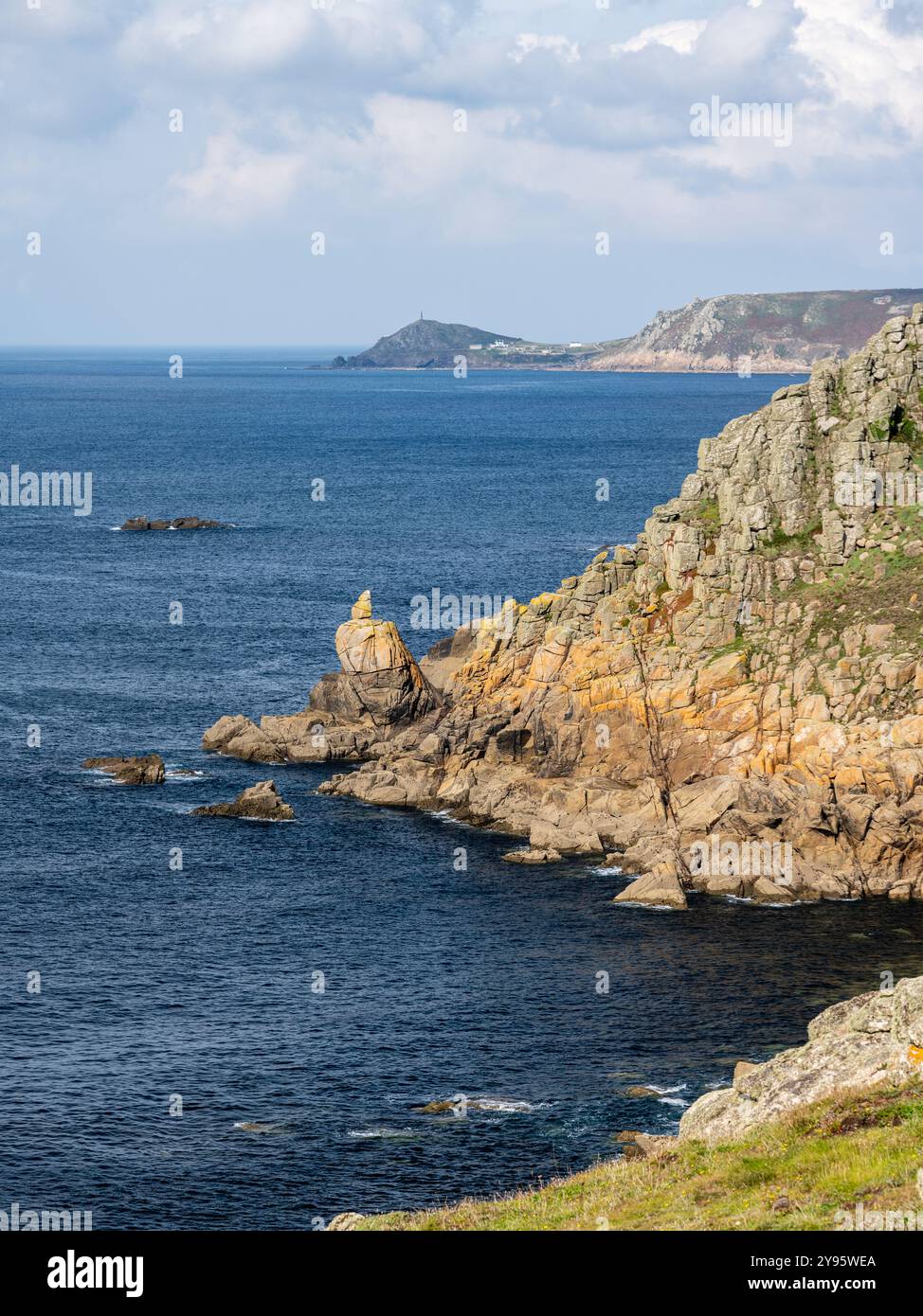 Die Sonne scheint auf den Klippen von Sennen im Westen von Cornwall, mit der Landzunge von Cape Cornwall in der Ferne. Stockfoto