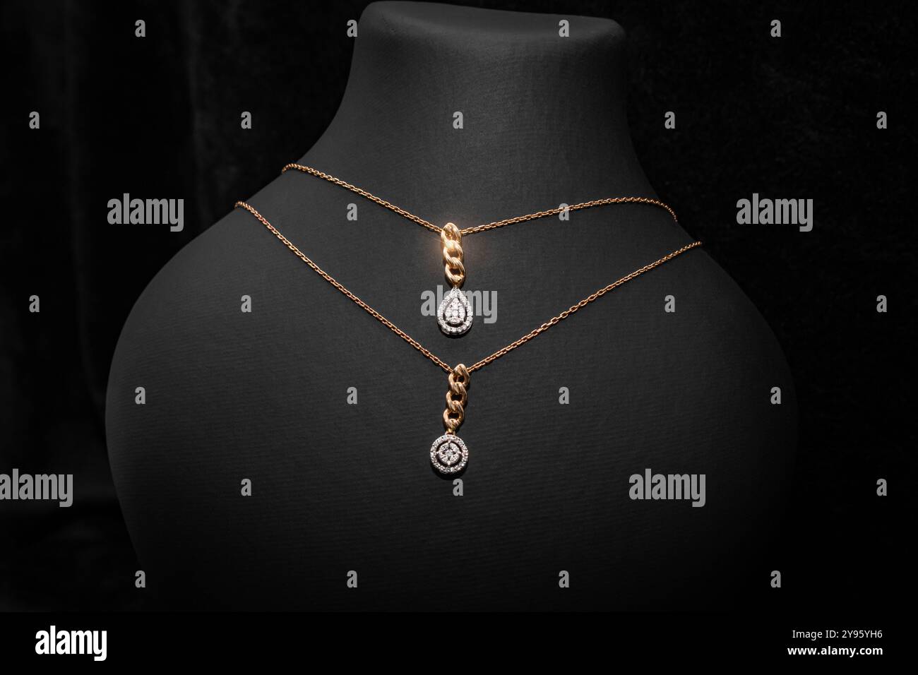 Ein passendes Set aus zwei Diamant-Anhänger-Halsketten, die jeweils eine andere Diamantform haben und an feinen Goldketten hängen. Dieses elegante Set ist perfekt für La Stockfoto