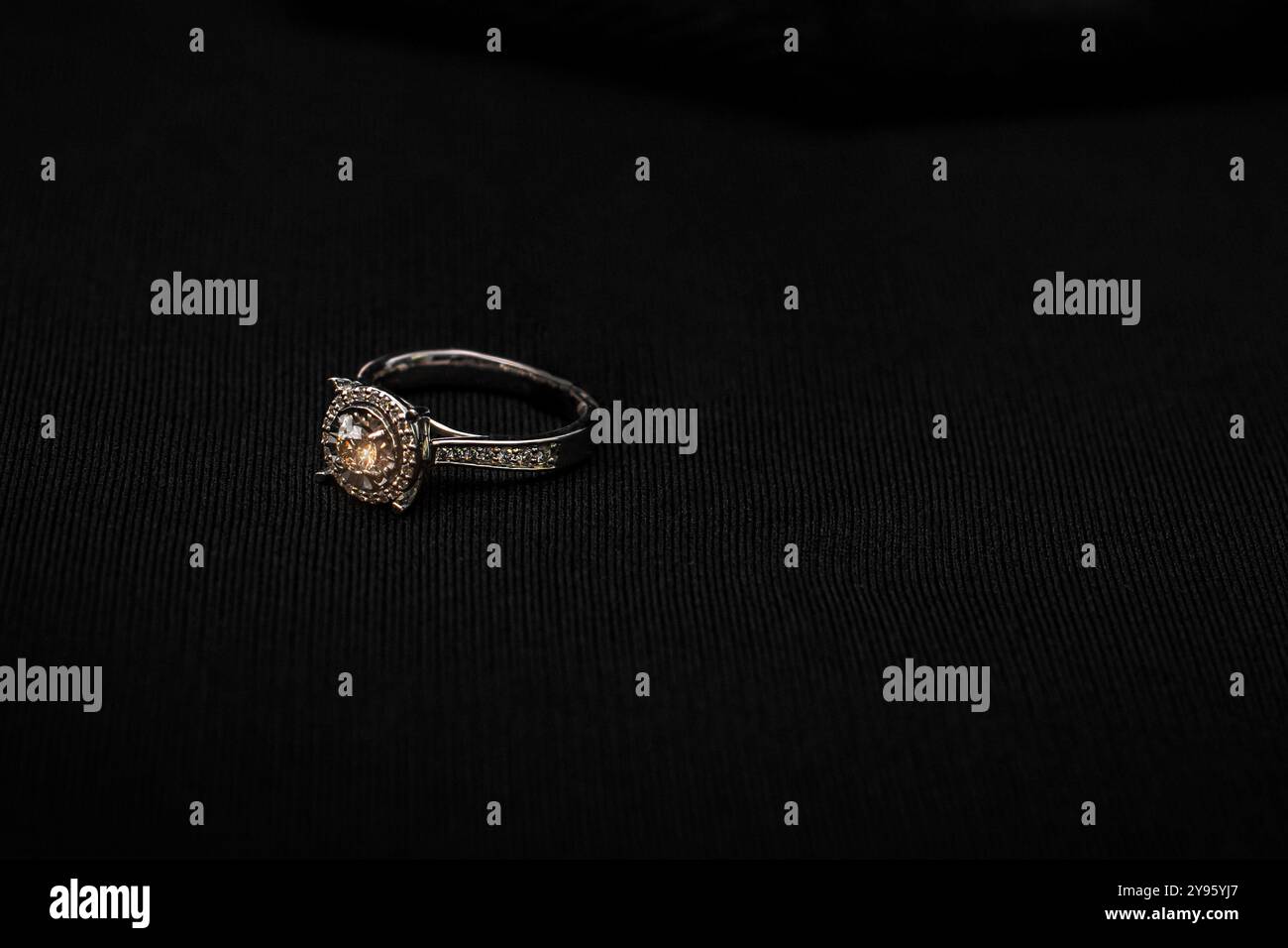 Ein atemberaubender Solitär-Diamant-Verlobungsring mit einem Halo aus kleineren Diamanten. Dieses elegante Stück kombiniert klassisches Design mit moderner Sophisti Stockfoto