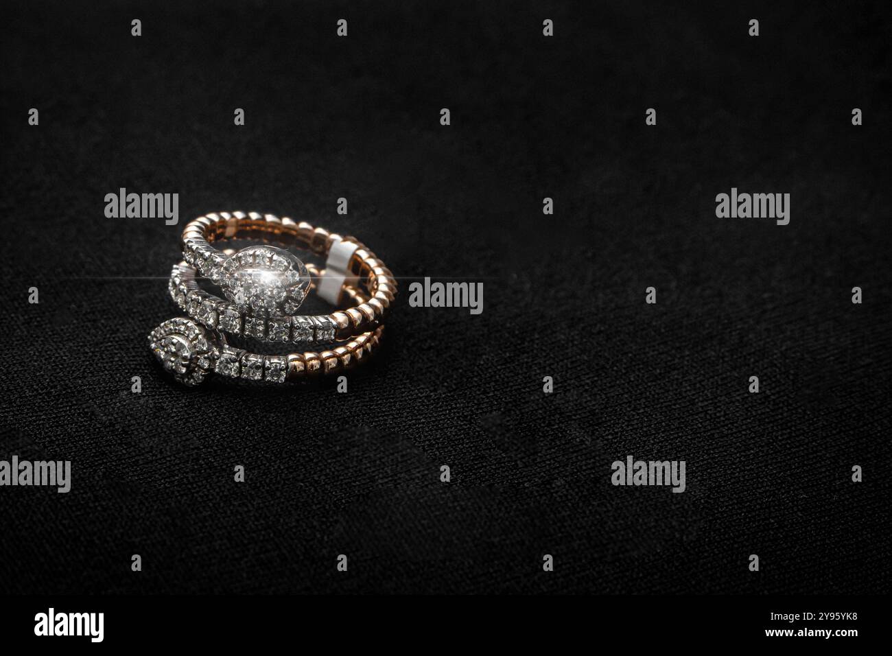 Ein Set aus zwei spiralförmigen Diamantringen, die mit funkelnden Diamanten in Gold verziert sind. Diese Ringe sind ein Statement-Accessoire, perfekt für einen Stockfoto