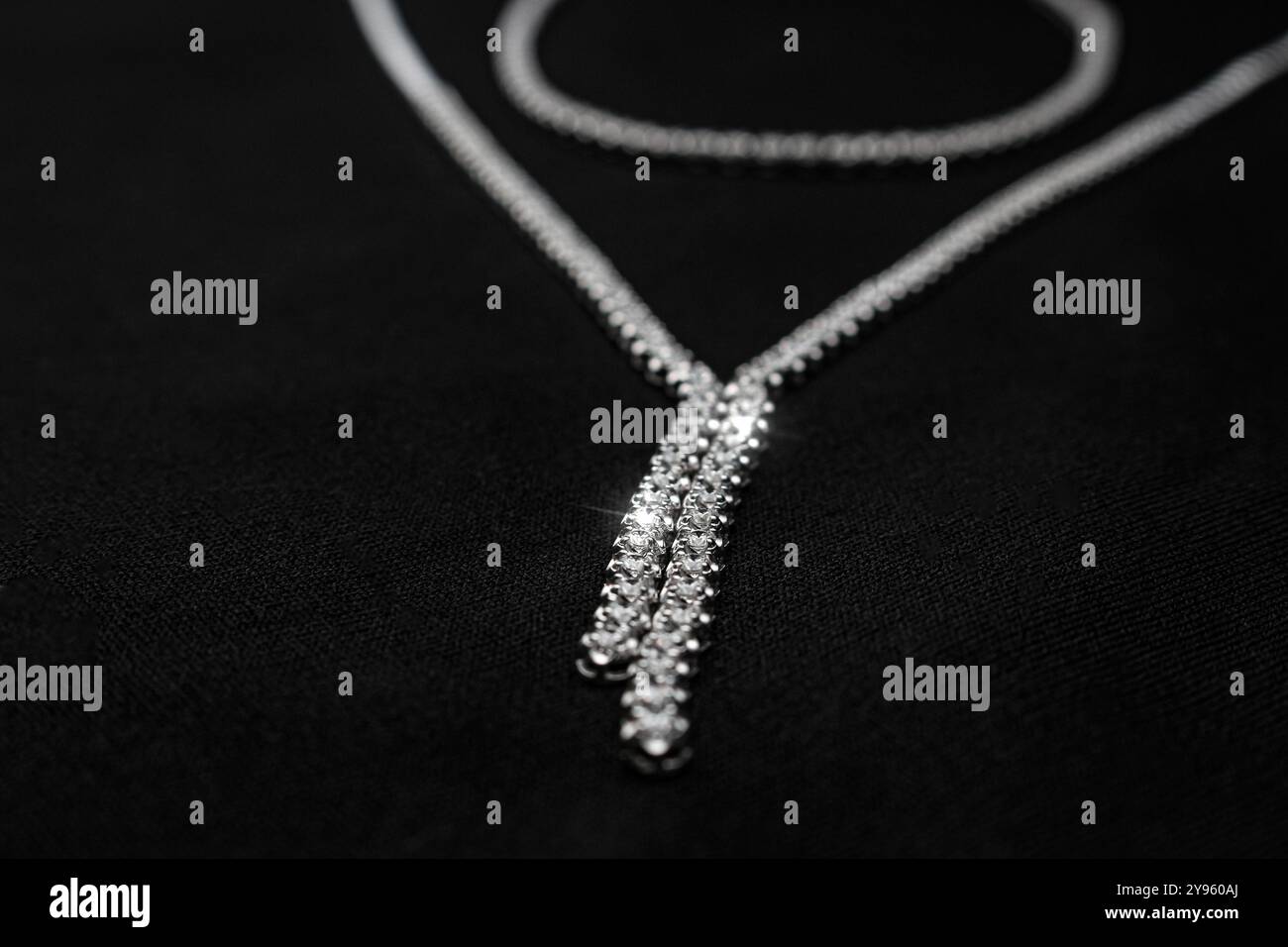 Eine luxuriöse Halskette mit Diamanten auf schwarzem Stoff mit Y-förmigem Design und brillanten Diamanten. Perfekt für High-End-Mode Stockfoto