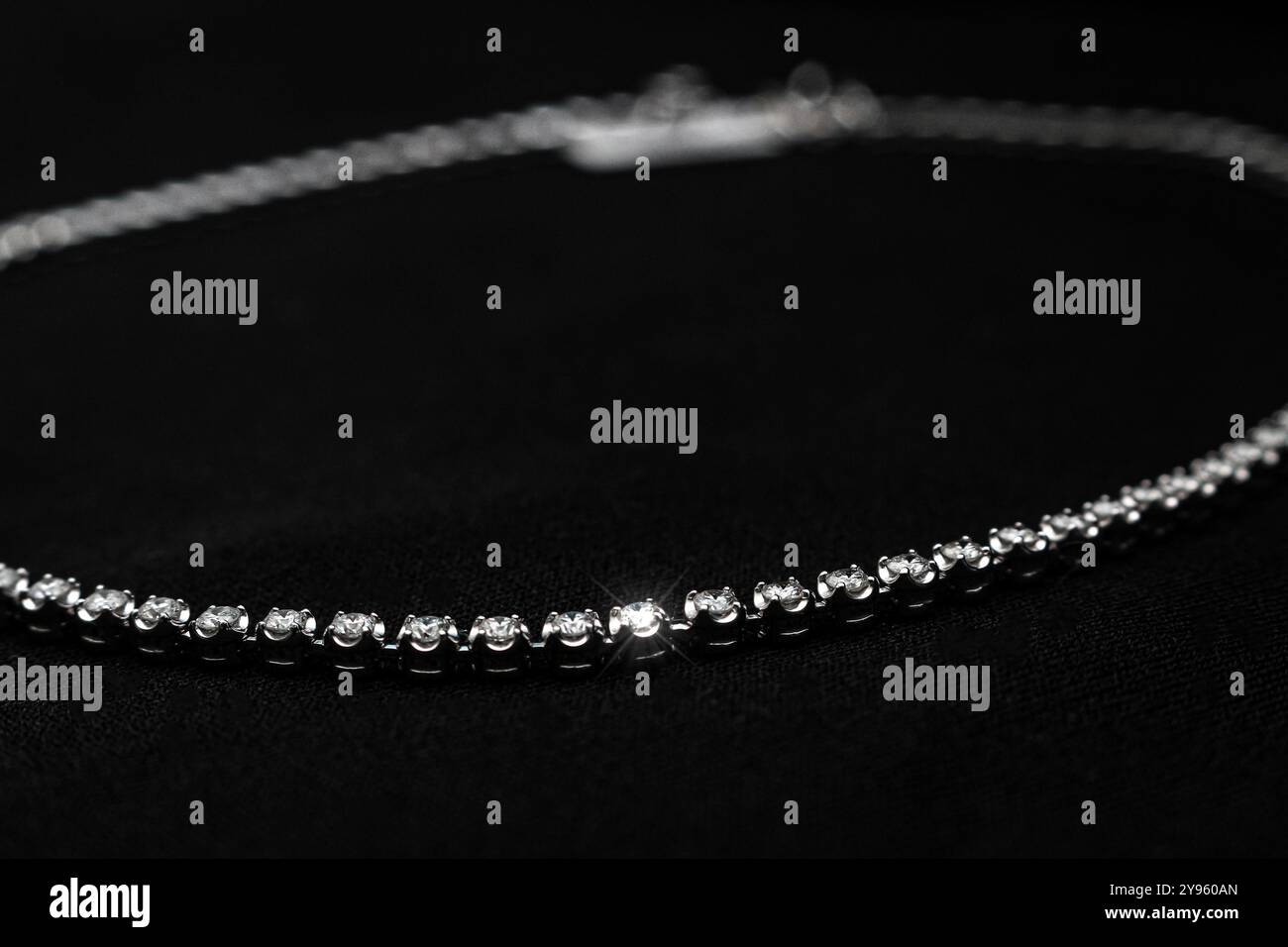 Eine luxuriöse Halskette mit Diamanten, einer zarten Kette und glänzenden Steinen vor schwarzem Hintergrund. Ideal für Brautschmuck, Modeaccessoires, Stockfoto