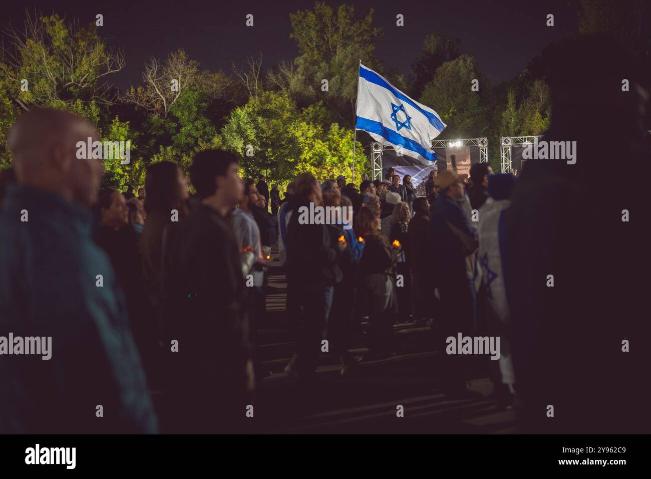 Toronto, Kanada. Oktober 2024. Während der Demonstration auf dem Sherman Campus wird eine israelische Flagge über einer Menschenmenge gehalten. Jüdische Gemeinden auf der ganzen Welt markierten den 7. Oktober, den tödlichsten Tag für das jüdische Volk seit dem Holocaust. Die UJA (United Jewish Appeal) Federation organisierte die Veranstaltung „7. Oktober: Marking One Year“ in Toronto, Kanada mit Gemeindemitgliedern, Verbündeten und Angehörigen von Geiseln, um Geschichten zu teilen, Kerzen anzuzünden und zusammen zu stehen, um die Ermordeten zu betrauern und die Überlebenden zu ehren. (Foto: Shawn Goldberg/SOPA Images/SIPA USA) Credit: SIPA USA/Alamy Live News Stockfoto