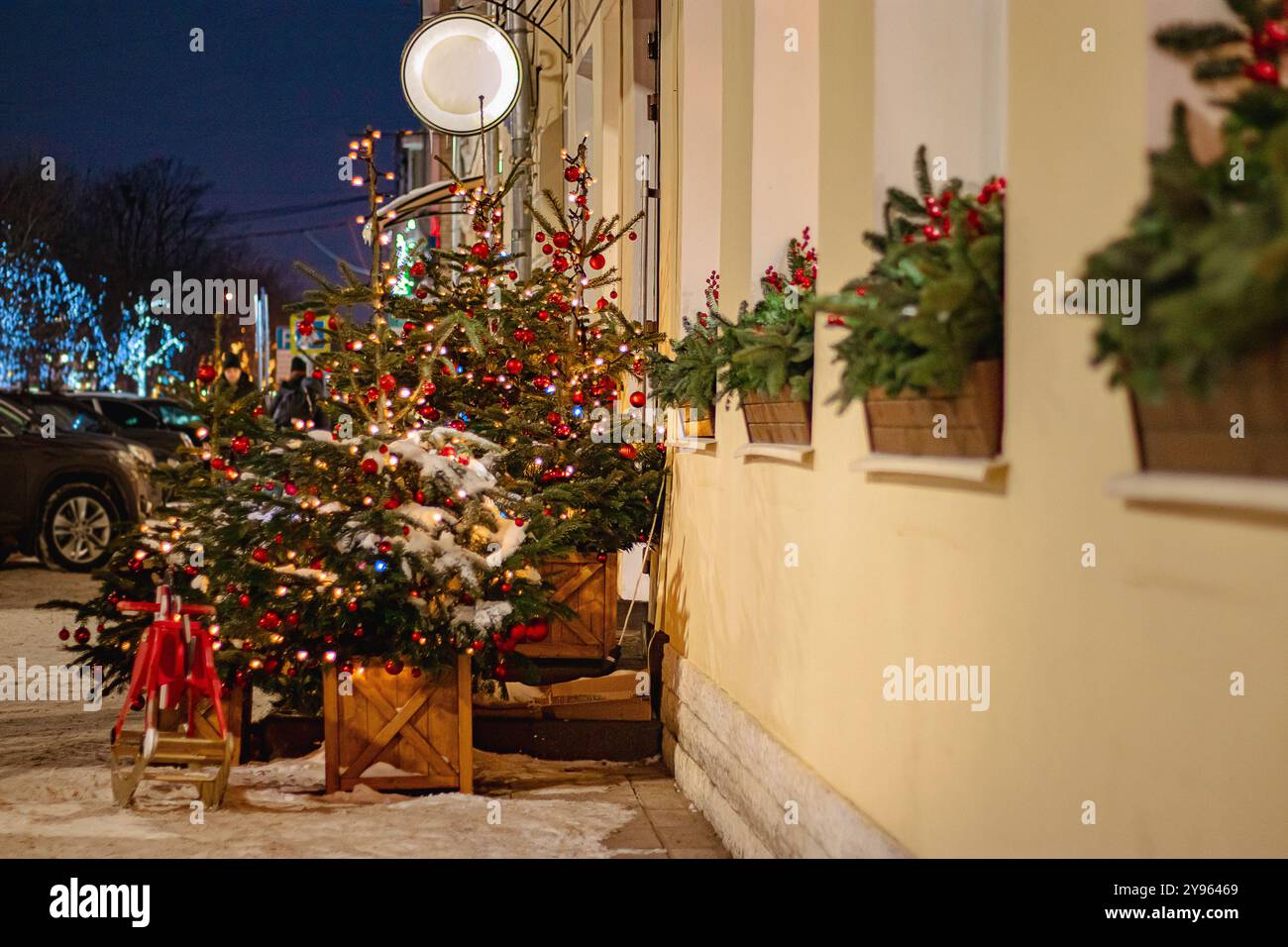 Weihnachtliche Straßendekoration. Festliche Bäume mit roten Weihnachtskugeln. Stadtdekoration für Silvester. Stockfoto