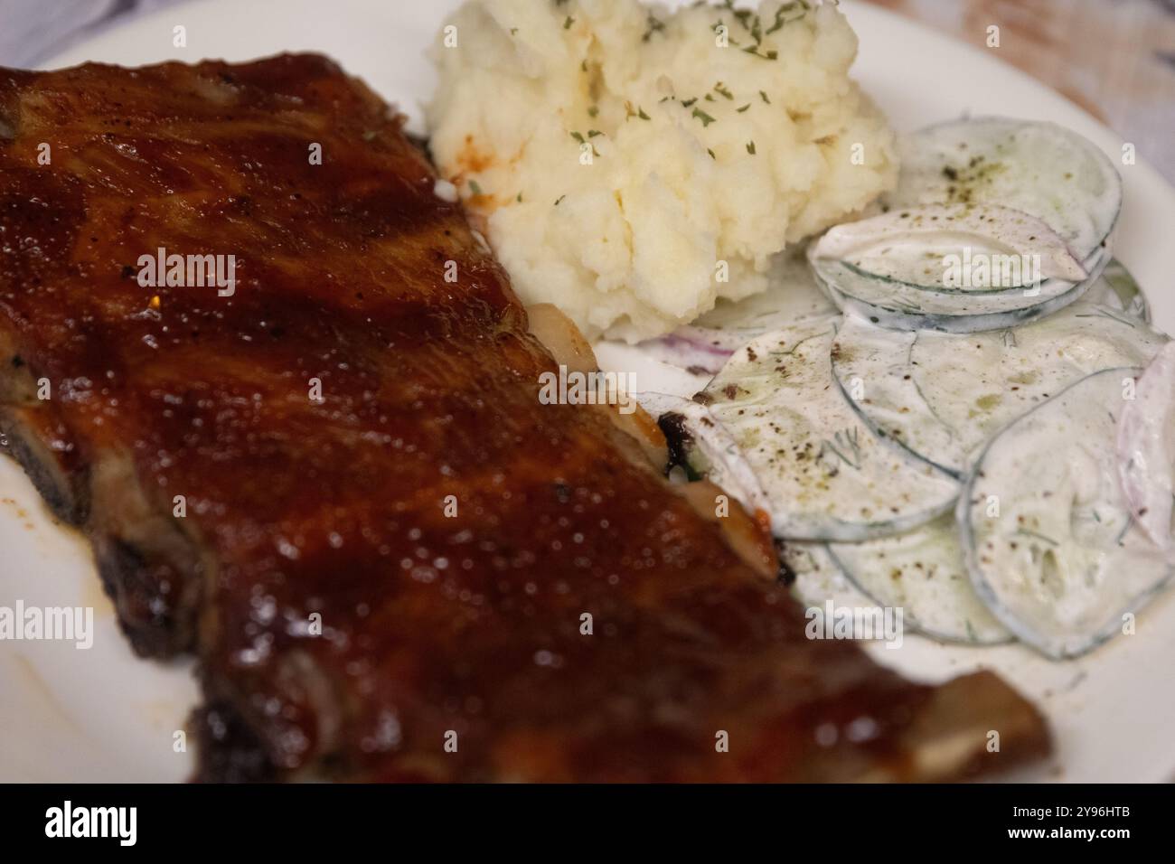 Rippendinner mit Kartoffelbrei und Gurkensalat Stockfoto