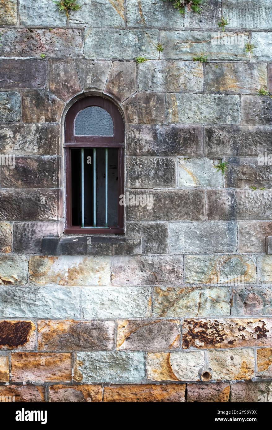 Vintage-Fenster mit farbenfroher Sandsteinwand, Ziegelwand, abstraktes grafisches Design. Stockfoto
