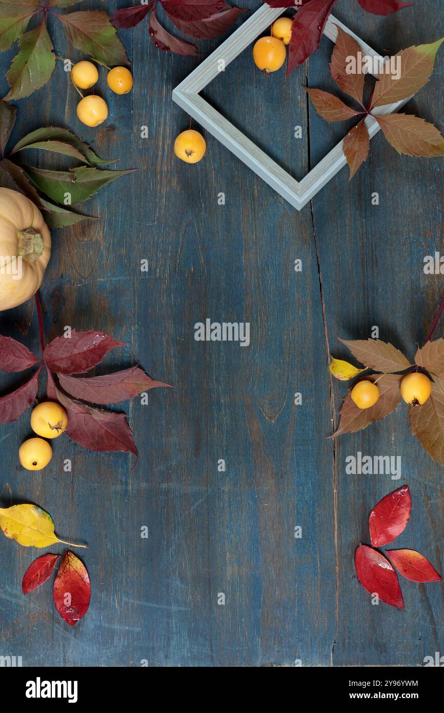 Rahmen aus Herbstblättern, Früchte auf Holzbrett. Urlaub und Essen. Hintergrund für die Konstruktion. Stockfoto