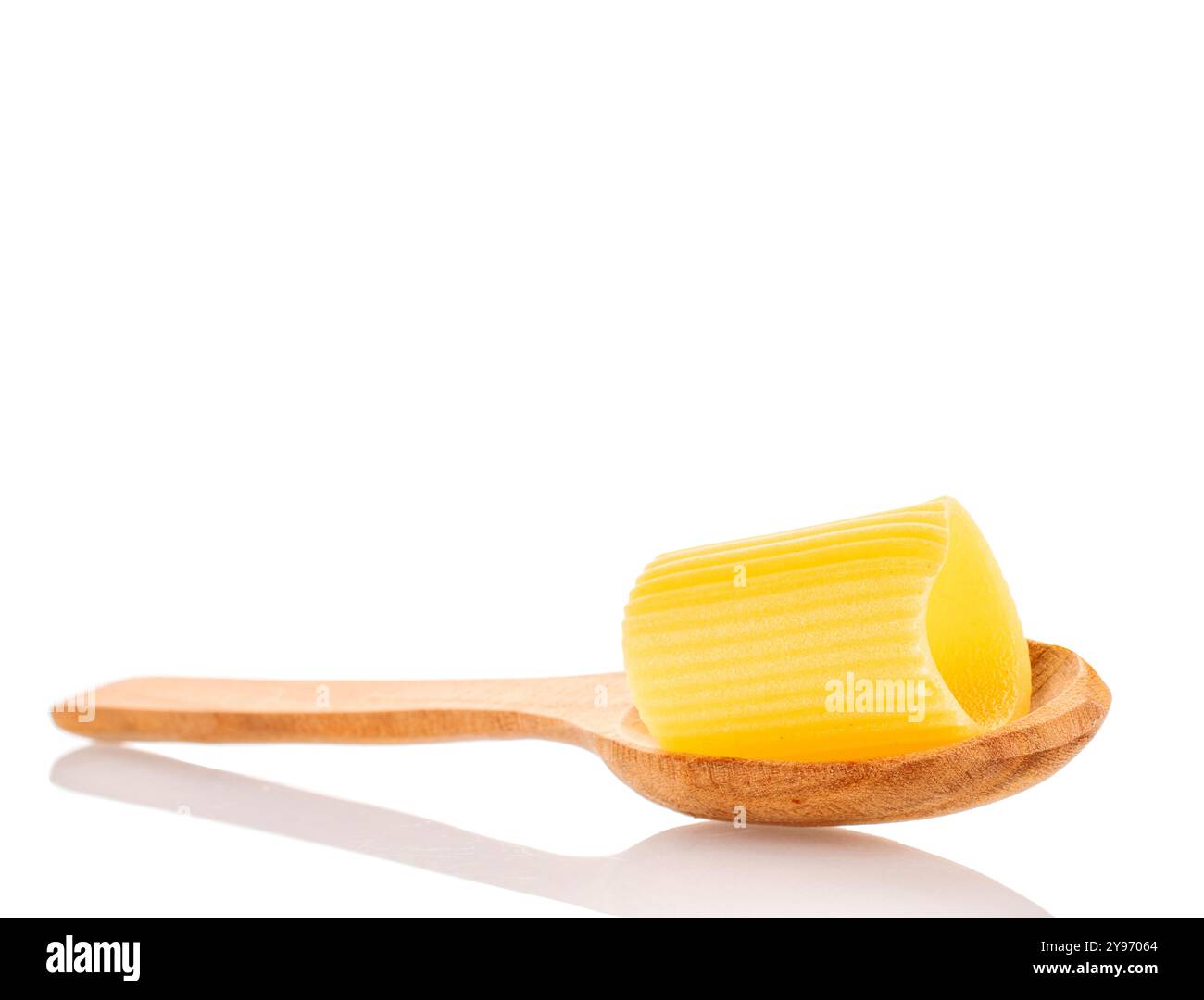 Rohe Cannelloni Hartweizen-Nudeln mit Holzlöffel, Makro, isoliert auf weißem Hintergrund. Stockfoto